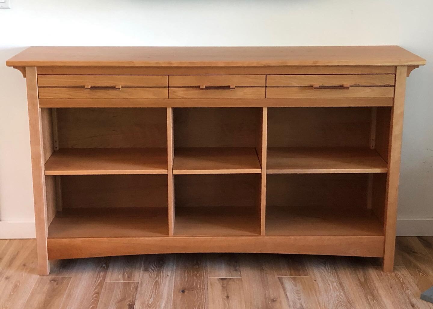 Custom cherry bookcase with walnut drawer pulls.