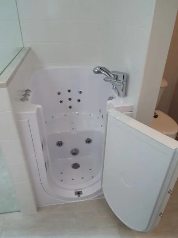 Closeup on a walk-in bathtub. The faucet and massage jets are visible.