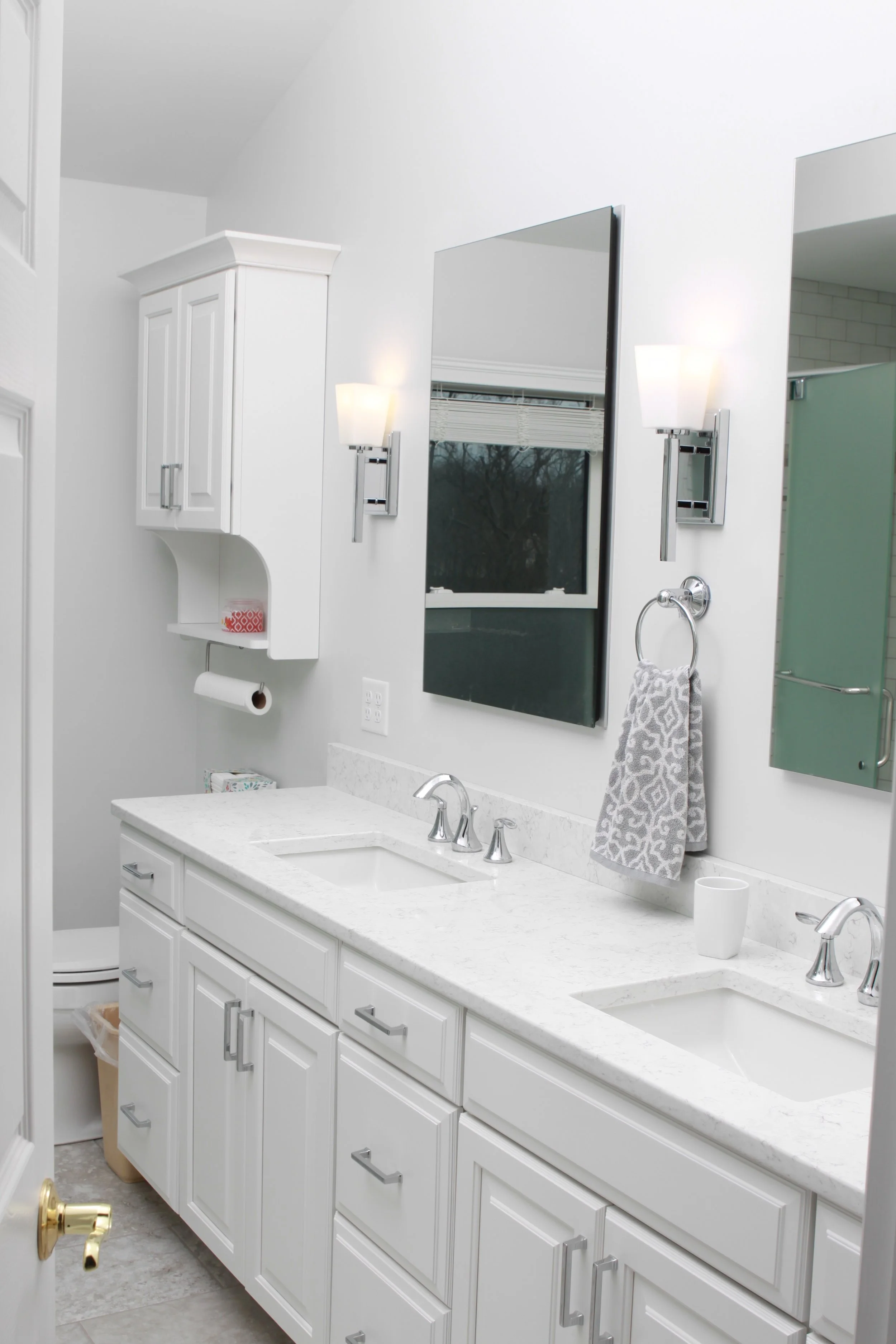 Light and airy white bathroom with double vanity sink and a mirror over each sink