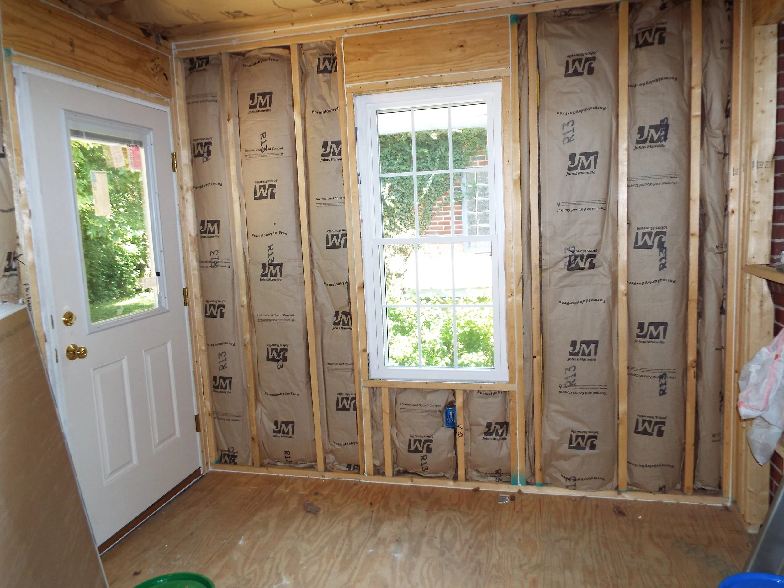 Interior view of construction - doors and windows installed, with studs and insulation