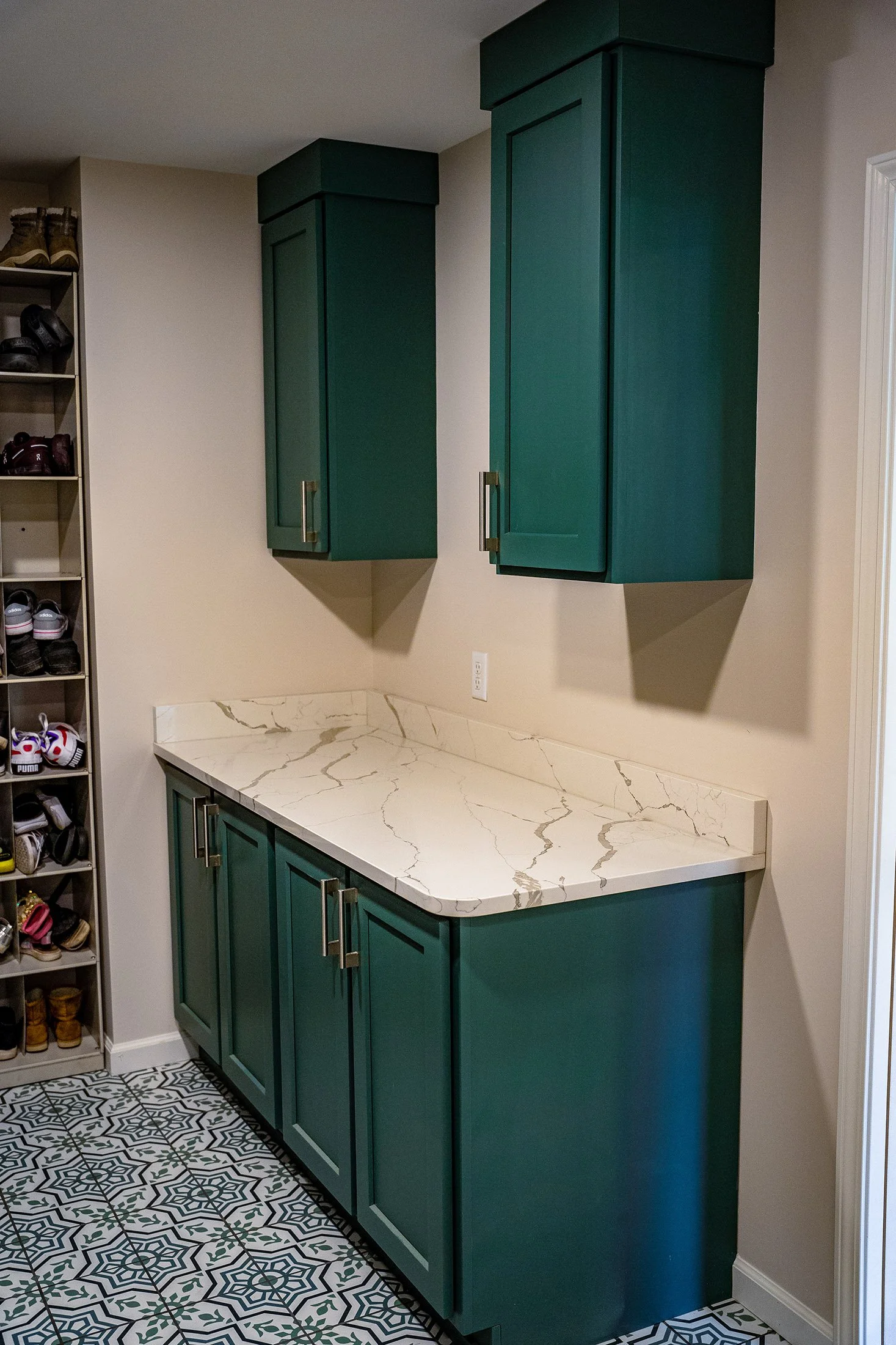 Complete First Floor Remodel by KBC Inc. 
Laundry Room counter and cabinets. Storage shelving on left side of photo.  LED lighting. Mosaic pattern tile floor.