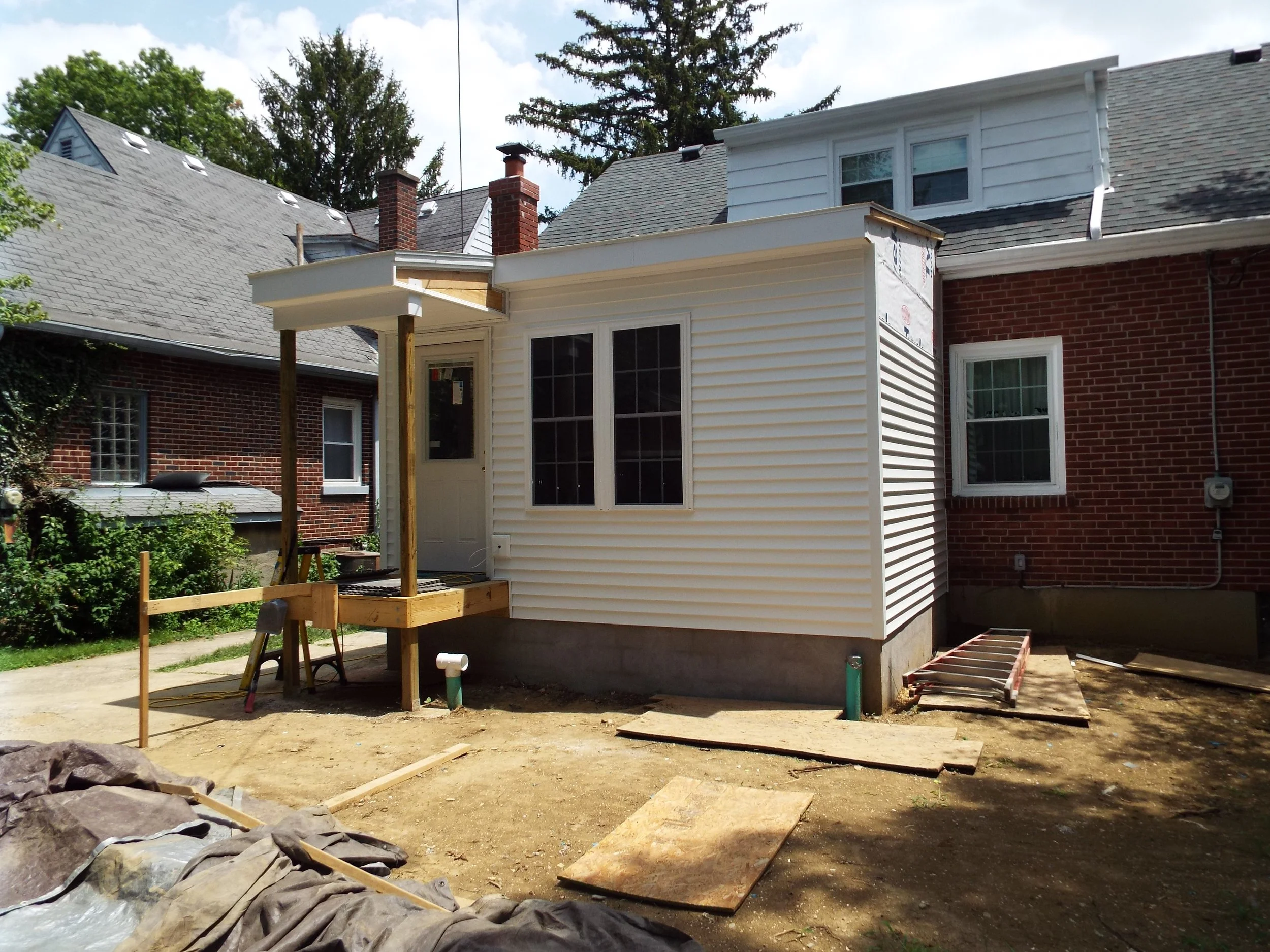 Outdoor view - siding windows and roof completed, beginning construction on outside steps