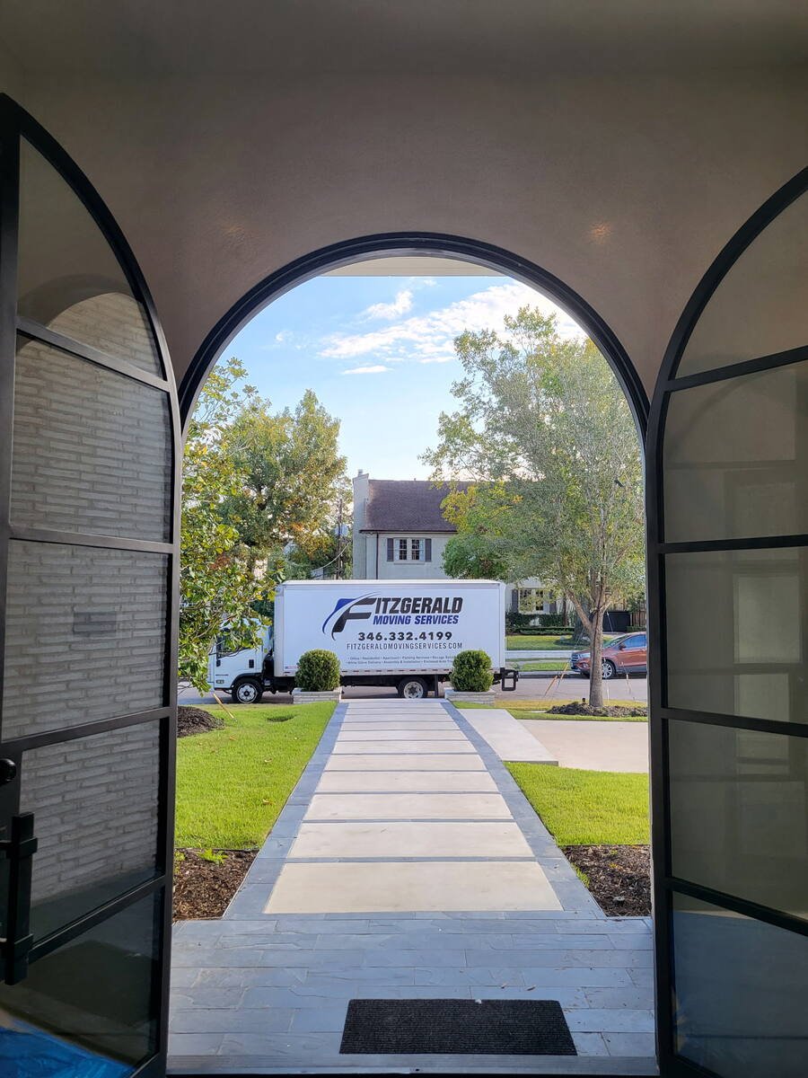 View from a Houston home's entry to a Fitzgerald Moving Services truck at the curb