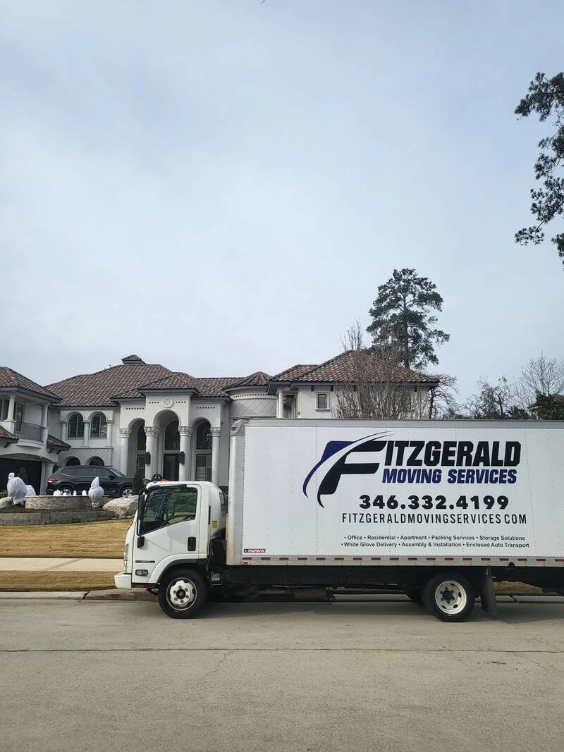 Fitzgerald Moving Services truck at a Mediterranean-style Houston home