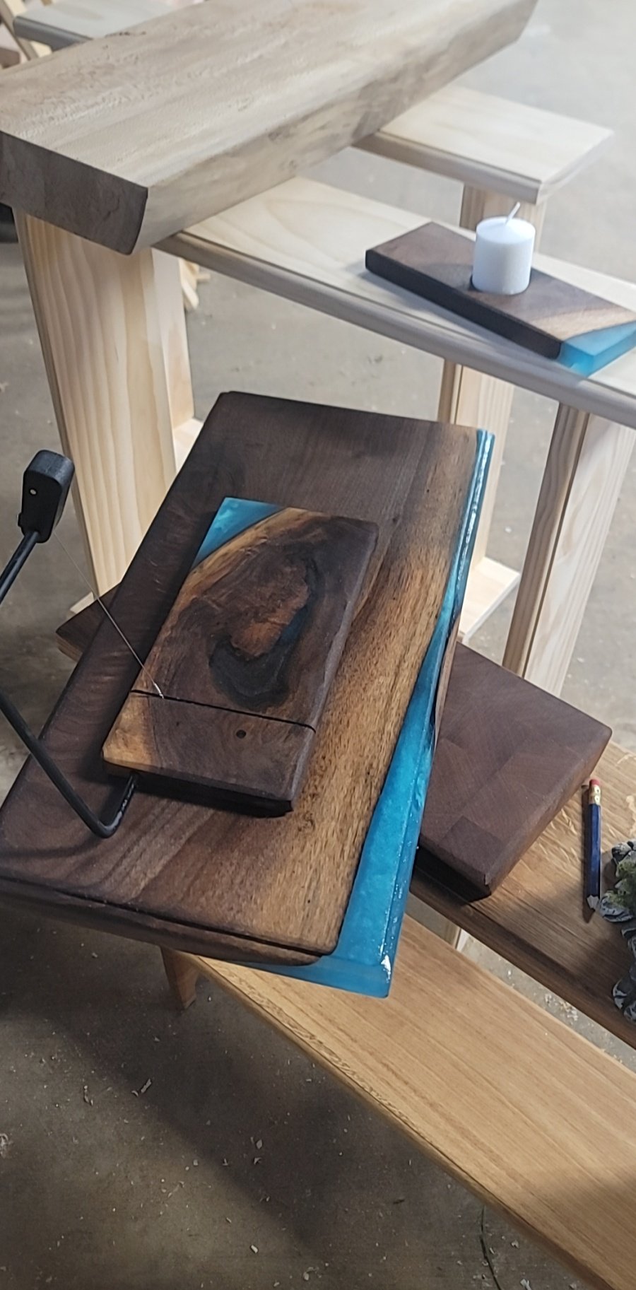 Close-up of a wooden workshop workbench with various wood pieces and a small candle.