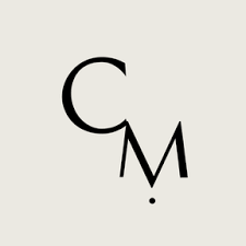 Monogram "CM" with a dot on a gray background.