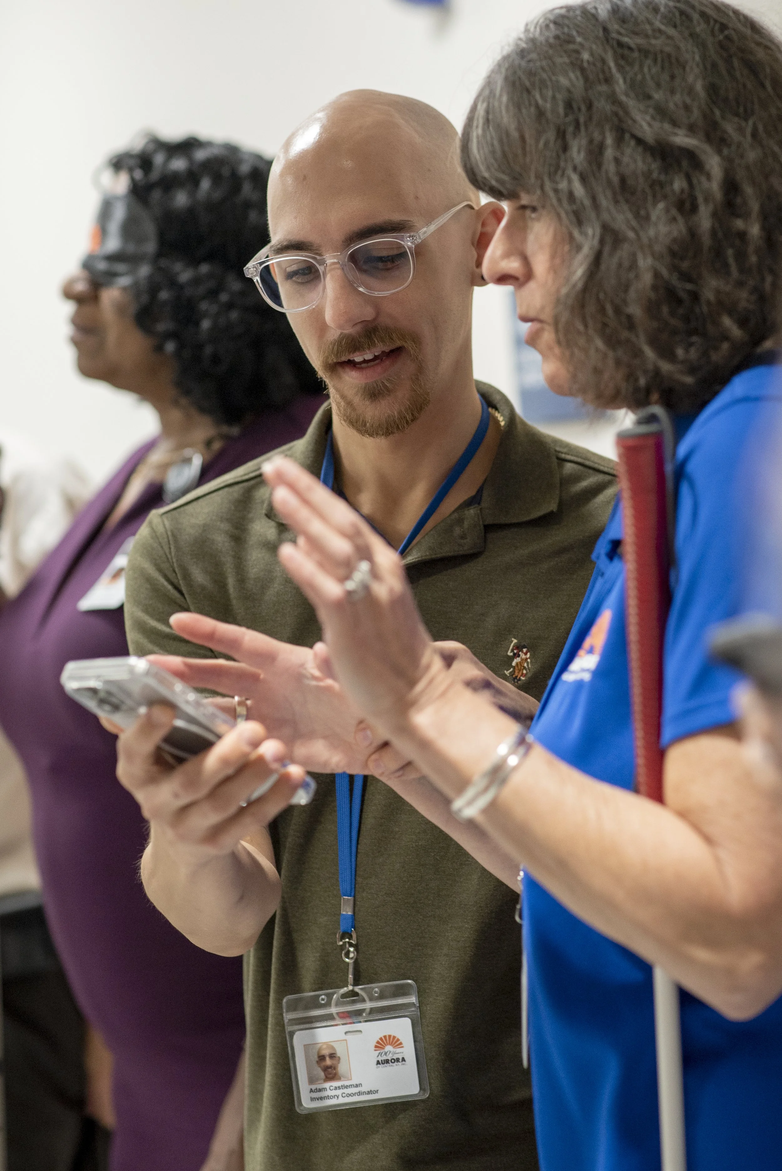 A man shows a woman something on his smartphone.