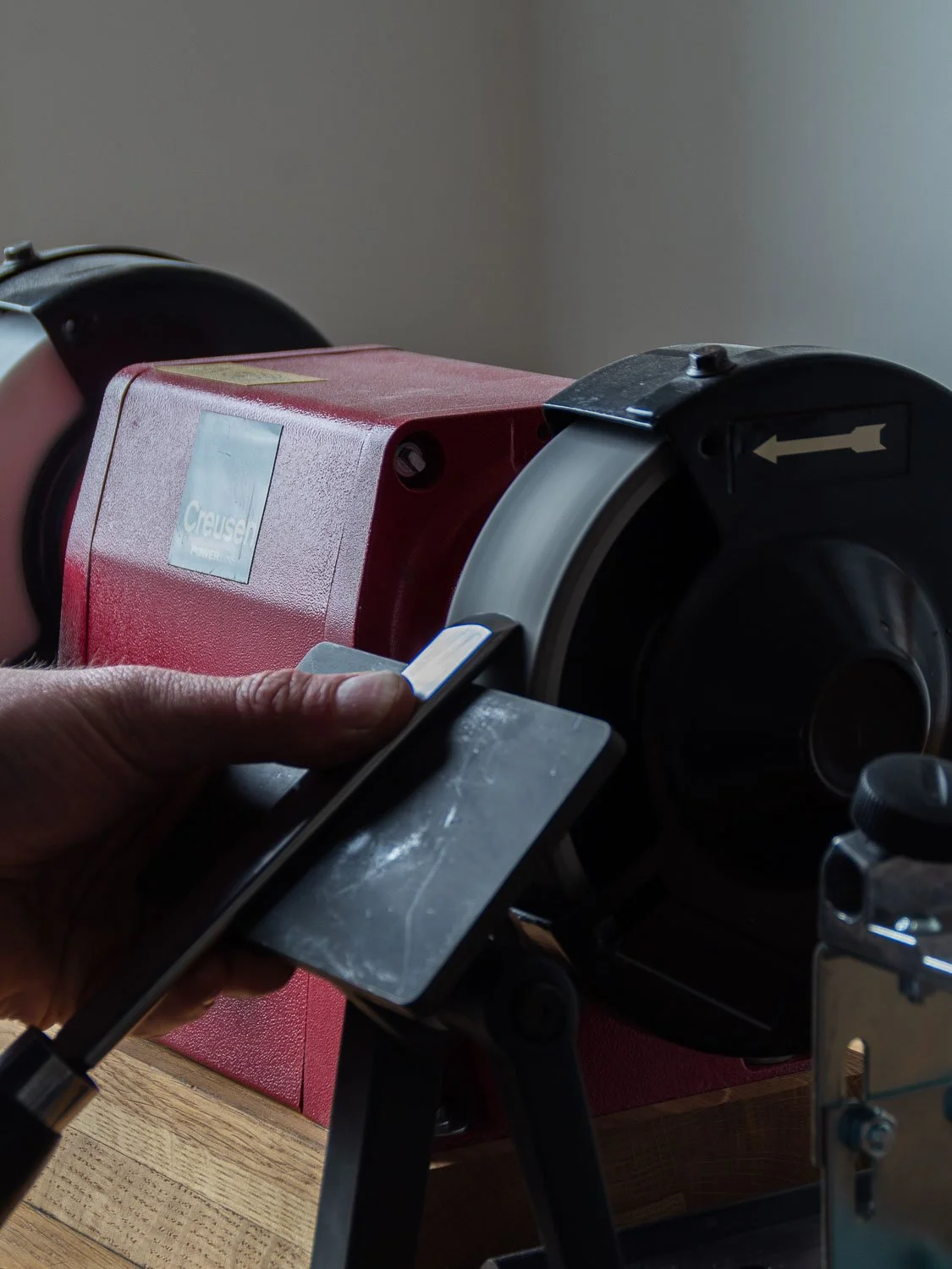 A person operating a Crusek laboratory centrifuge machine on a wooden table.