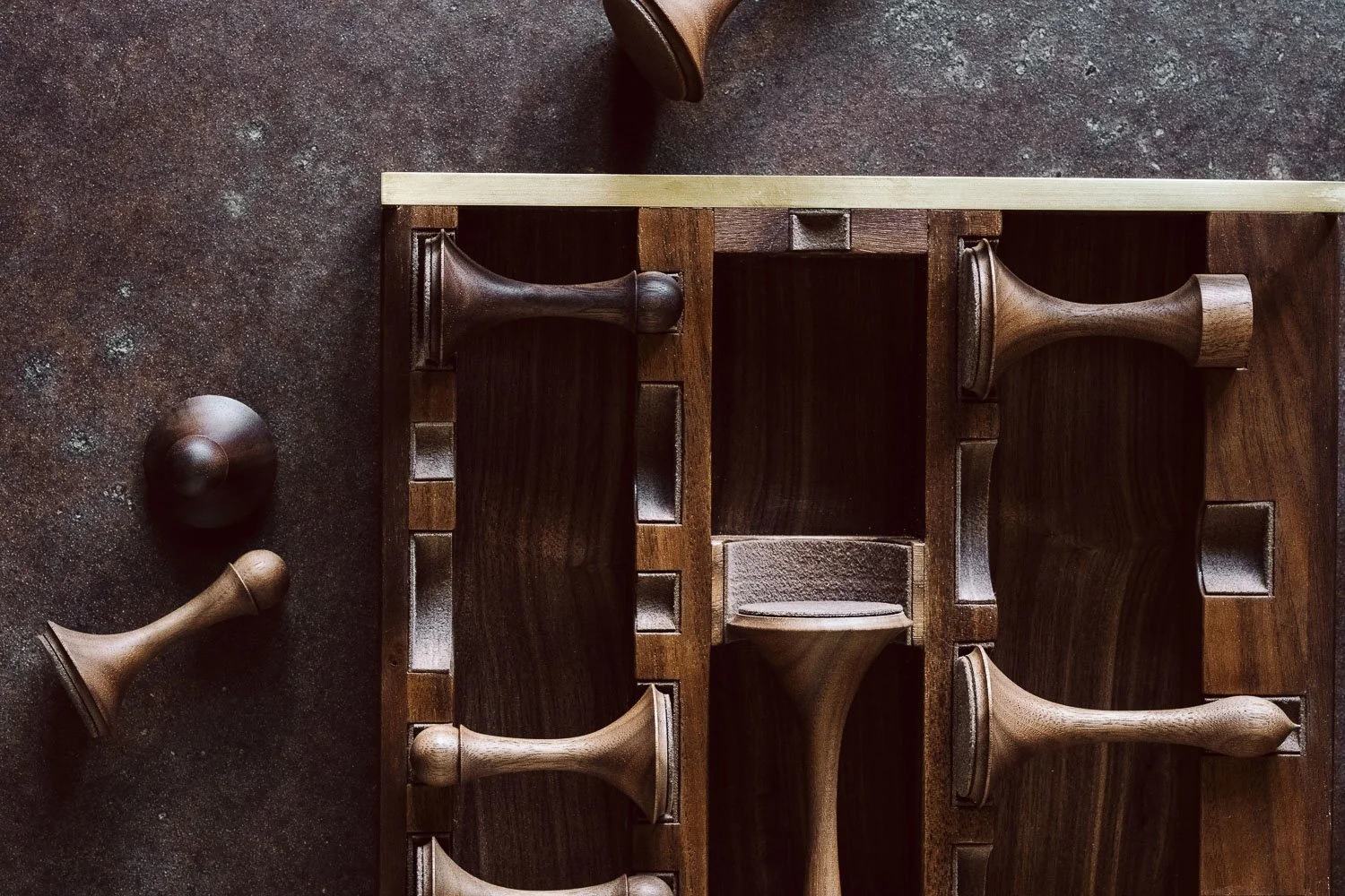 Overhead view of a chessboard with fallen chess pieces on a dark, textured surface.