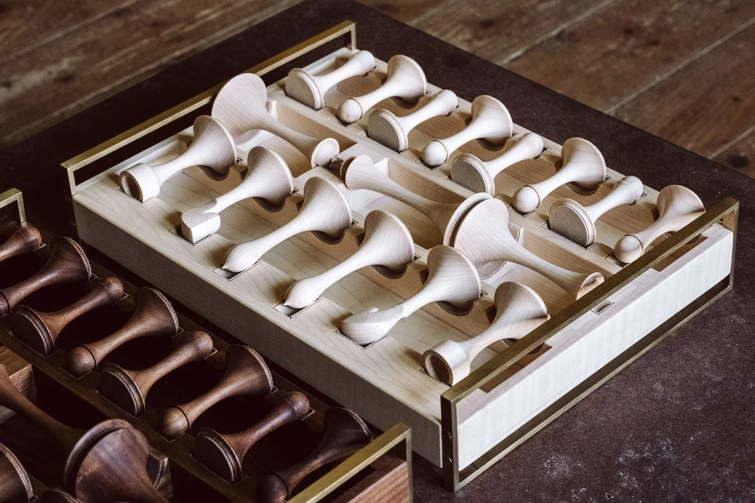 Wooden dominoes in a box, placed on a dark surface.