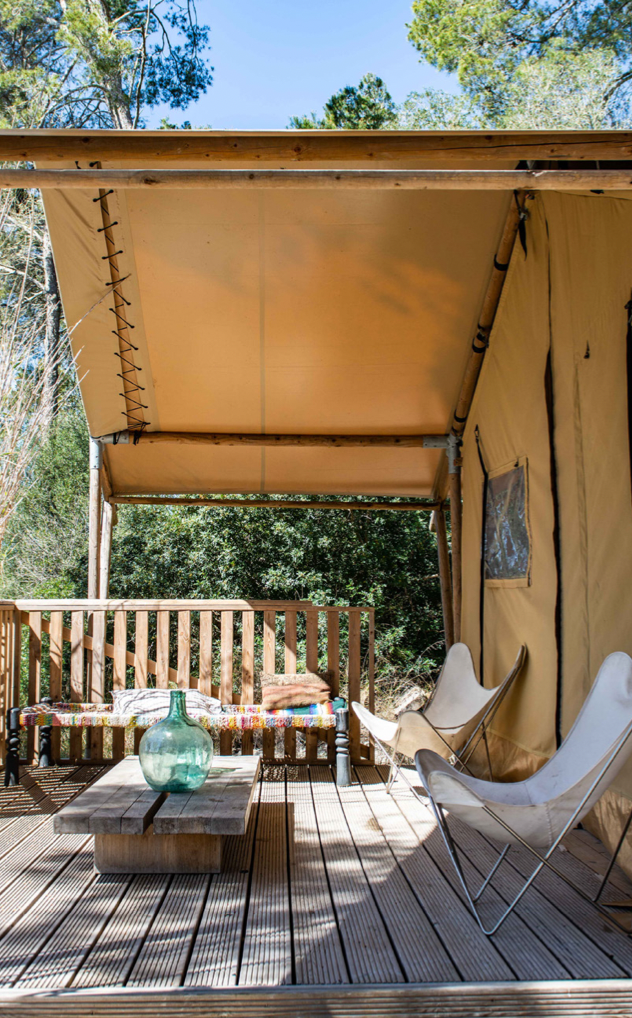 Orange safari tent with bench and chairs