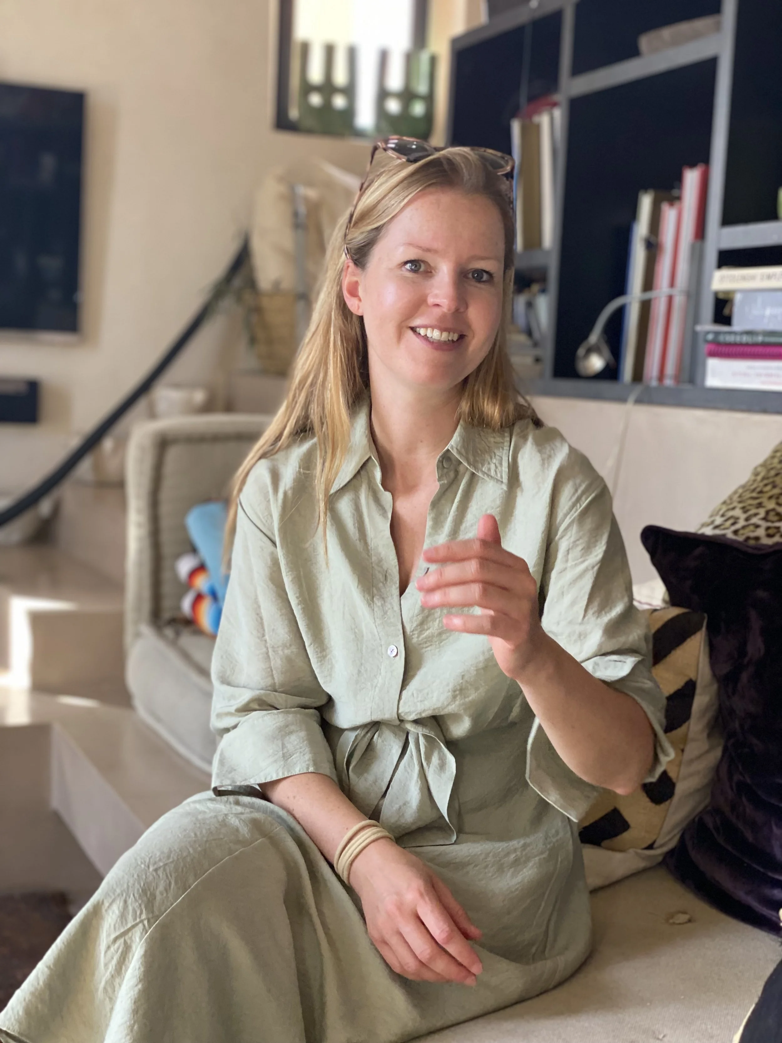 Blond woman in green dress sitting and talking 