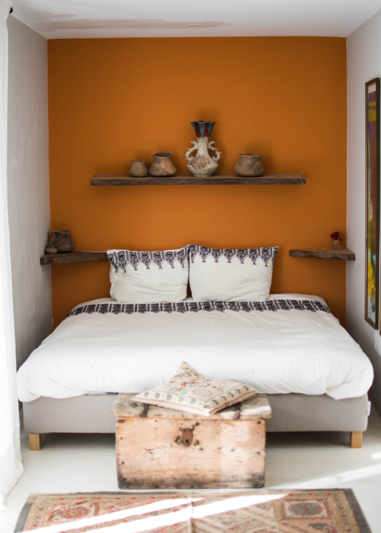 Double bed in front of red wall