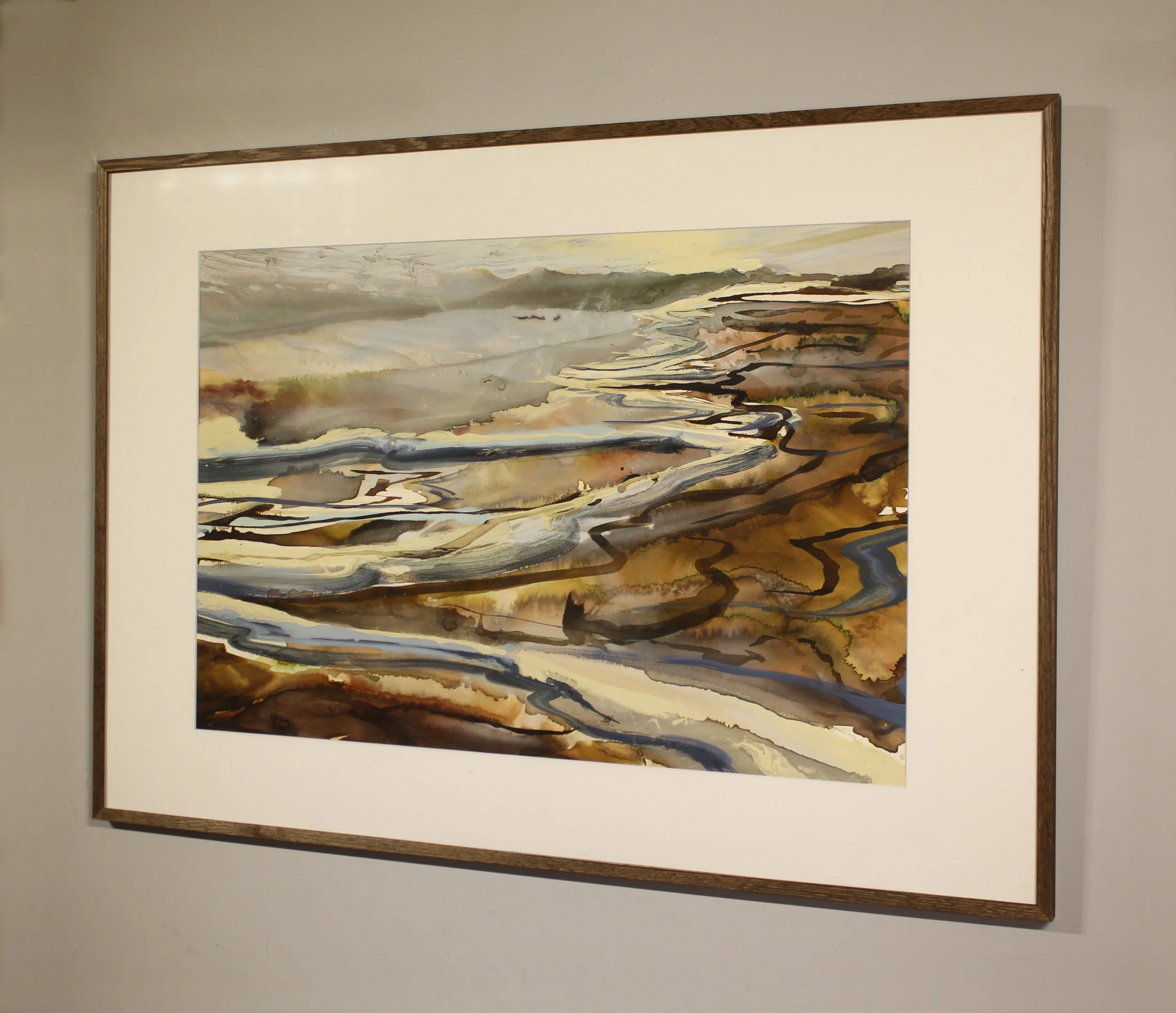 An abstracted ink painting that suggests waves depositing into to the beach. Paint and ink has been poured, seeped and dripped onto the surface in a calligraphic style with earth tones, frothy lemon whites and deeper slate grey tones.