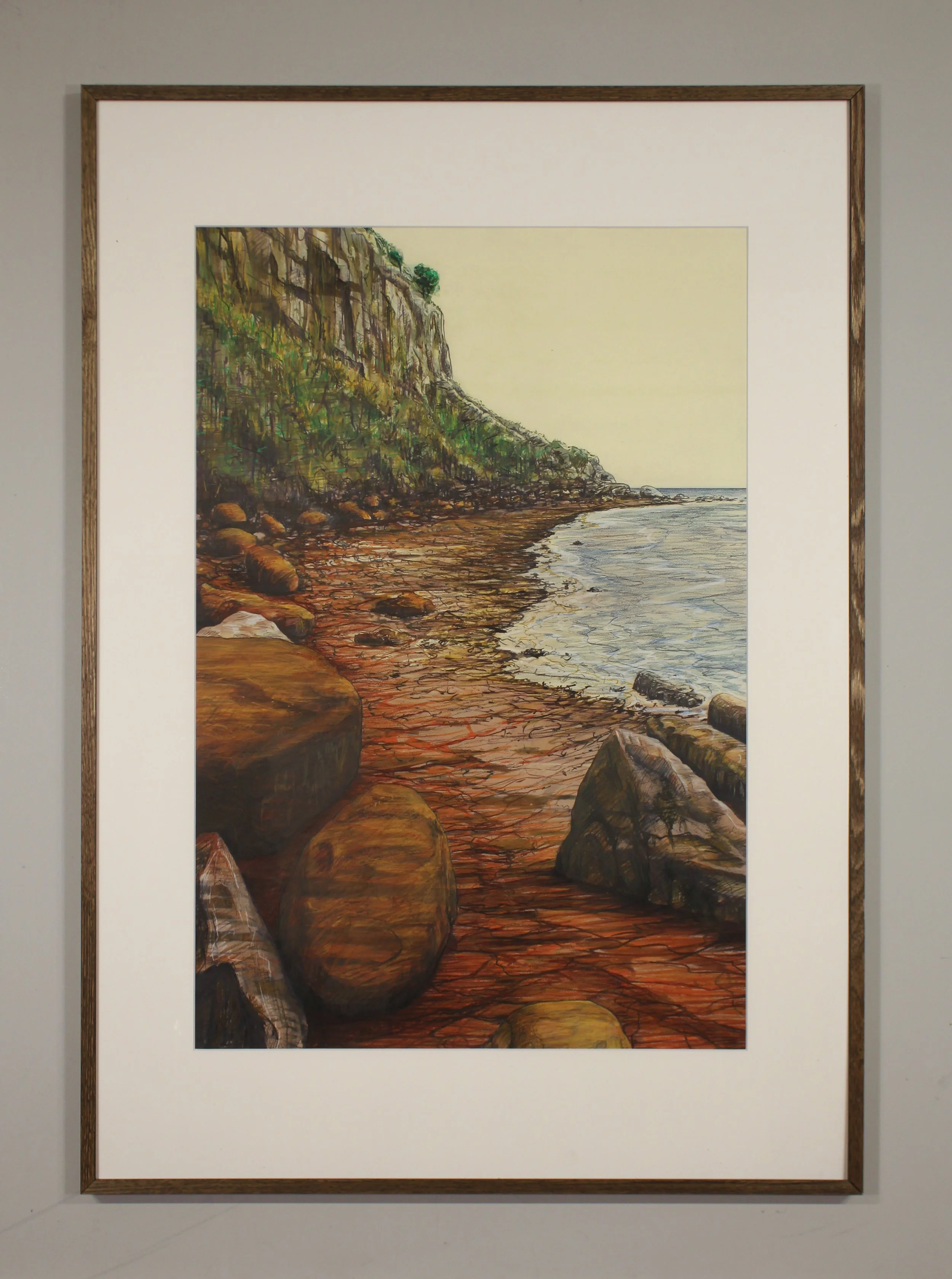 A detailed landscape drawing from the rocky shoreline at Bonchurch on the Isle of Wight where the rusty red iron in the earth and rocks seeps into the sea staining the beach orange in veined rivulets. This coastal seascape captures the large boulders