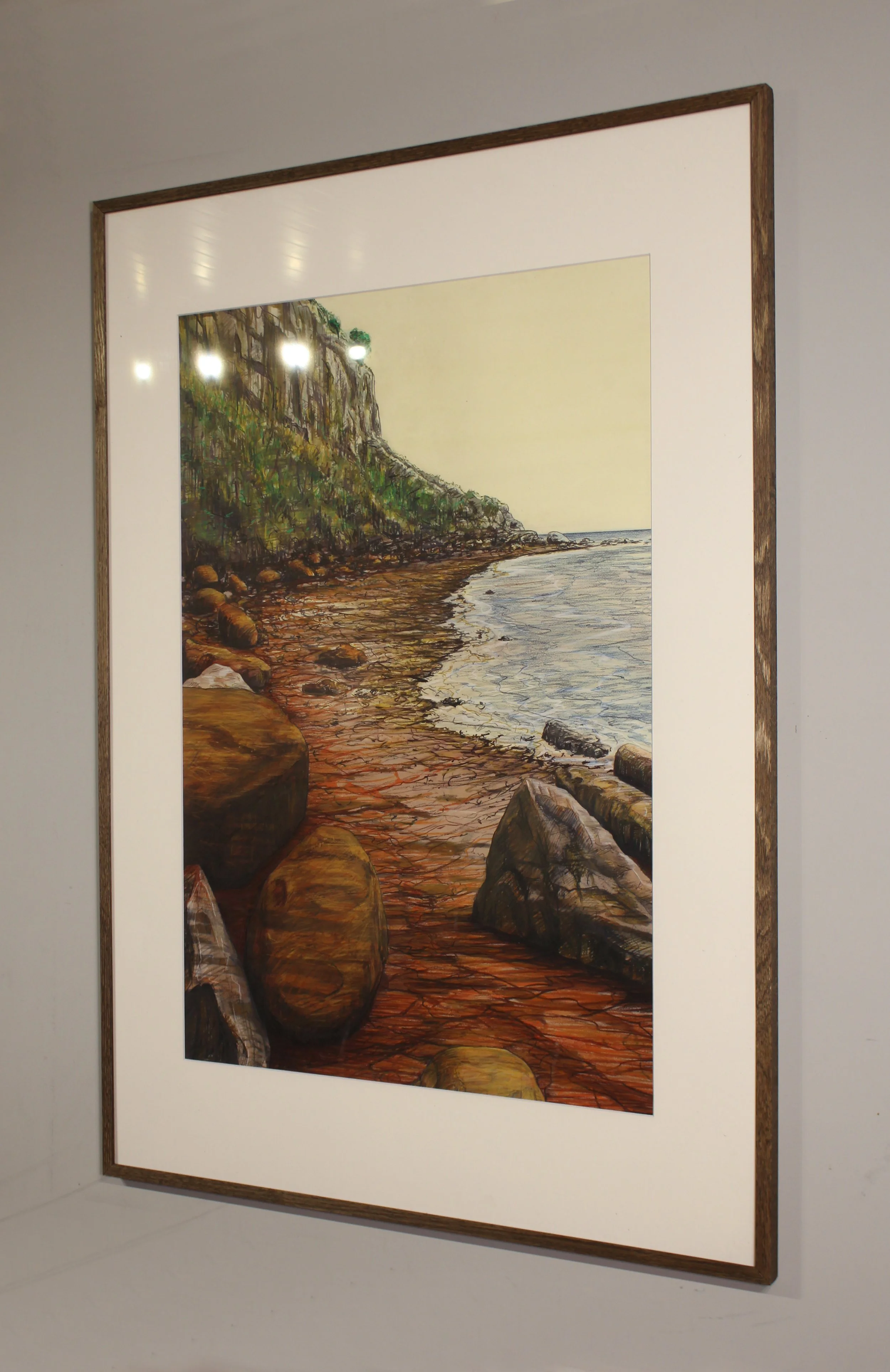 A detailed landscape drawing from the rocky shoreline at Bonchurch on the Isle of Wight where the rusty red iron in the earth and rocks seeps into the sea staining the beach orange in veined rivulets. This coastal seascape captures the large boulders