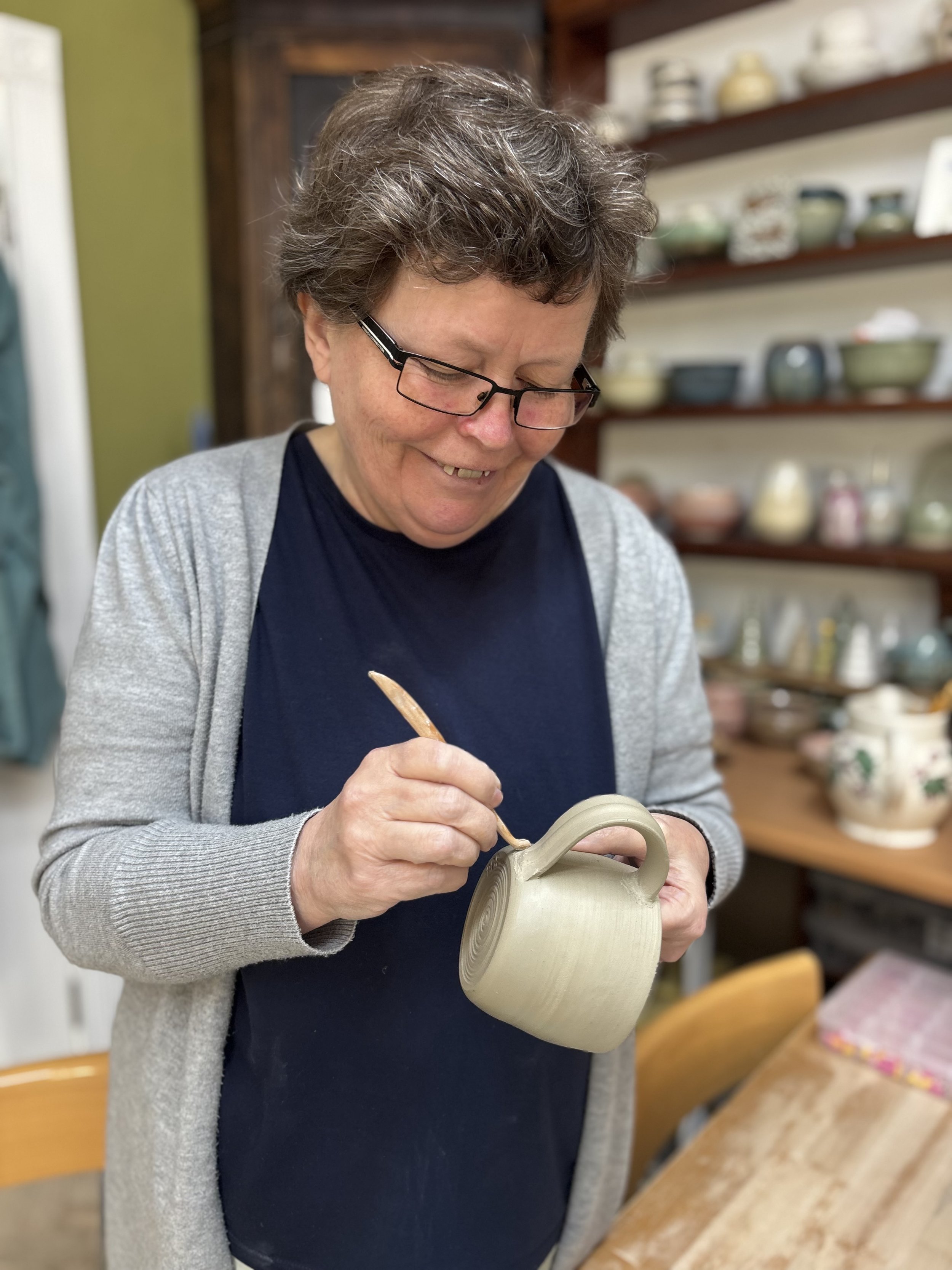   
  Bernie has been learning how to trim her pieces & attach handles to her mugs! 
 