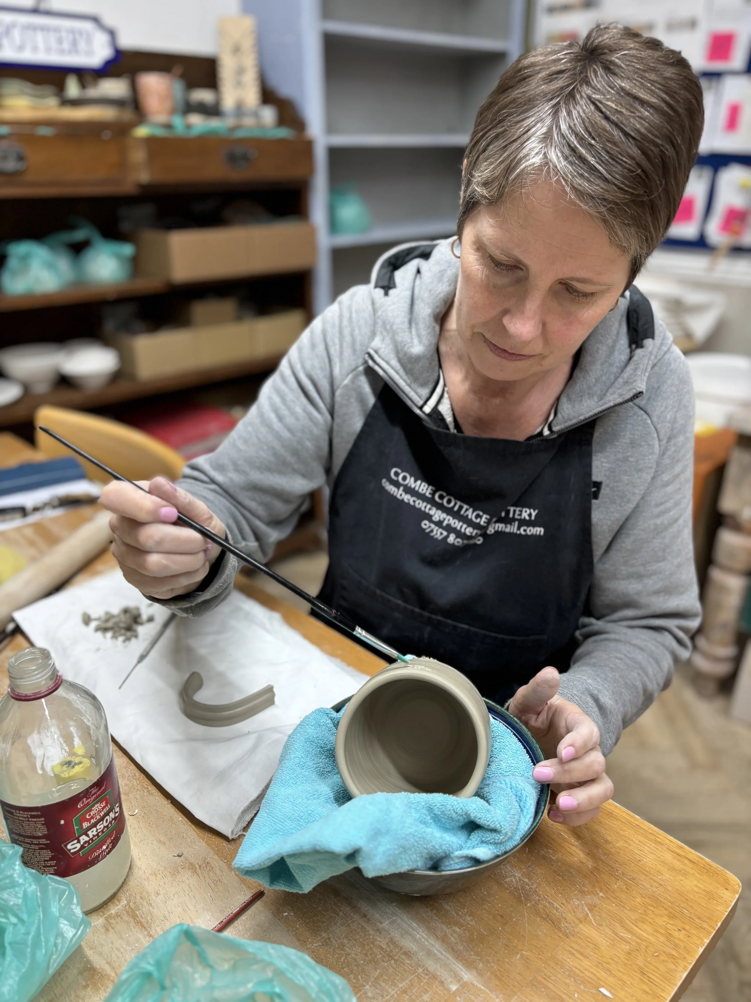   
 ... & adding handles to their first mugs!  
 