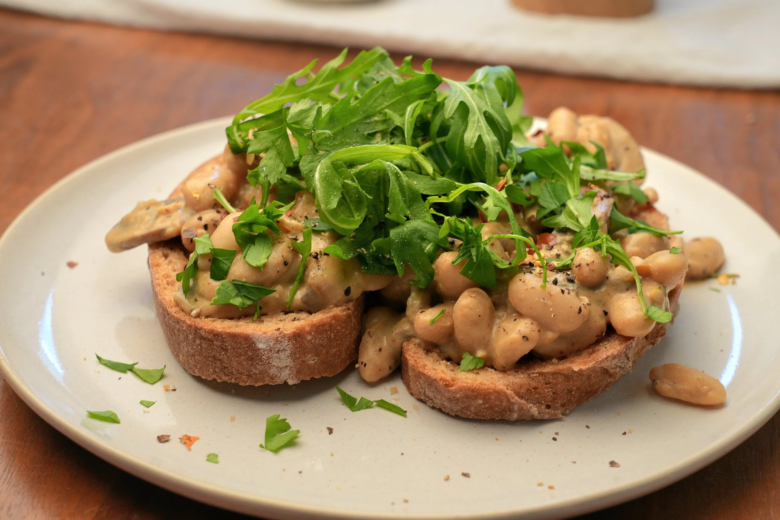 creamy miso mushroom cannellini beans with silken tofu high protein vegan batch cook meal prep image close up on toast with rocket