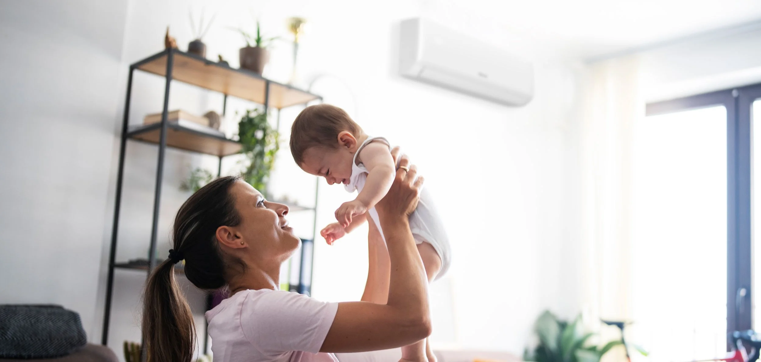 Inverter Split Air Conditioner on wall in family room with mother and baby