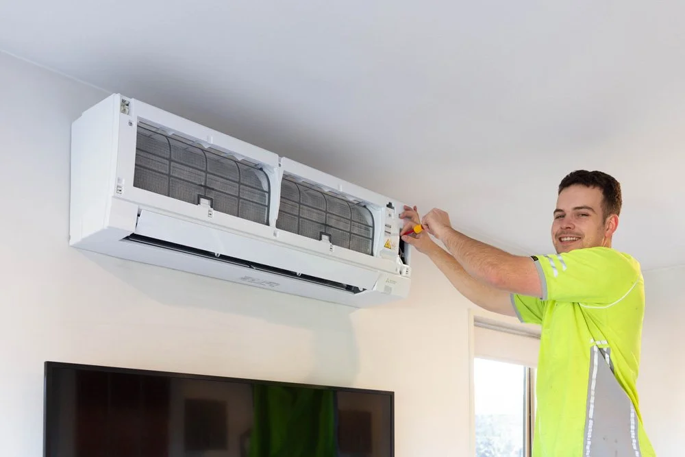 heat pump technician working on indoor unit