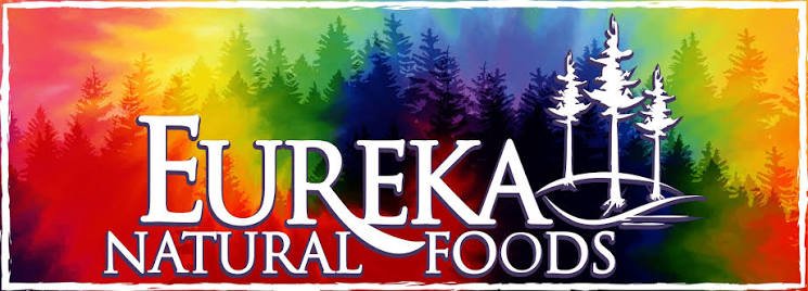 Eureka Natural Foods logo with a colorful rainbow forest background and white pine trees.