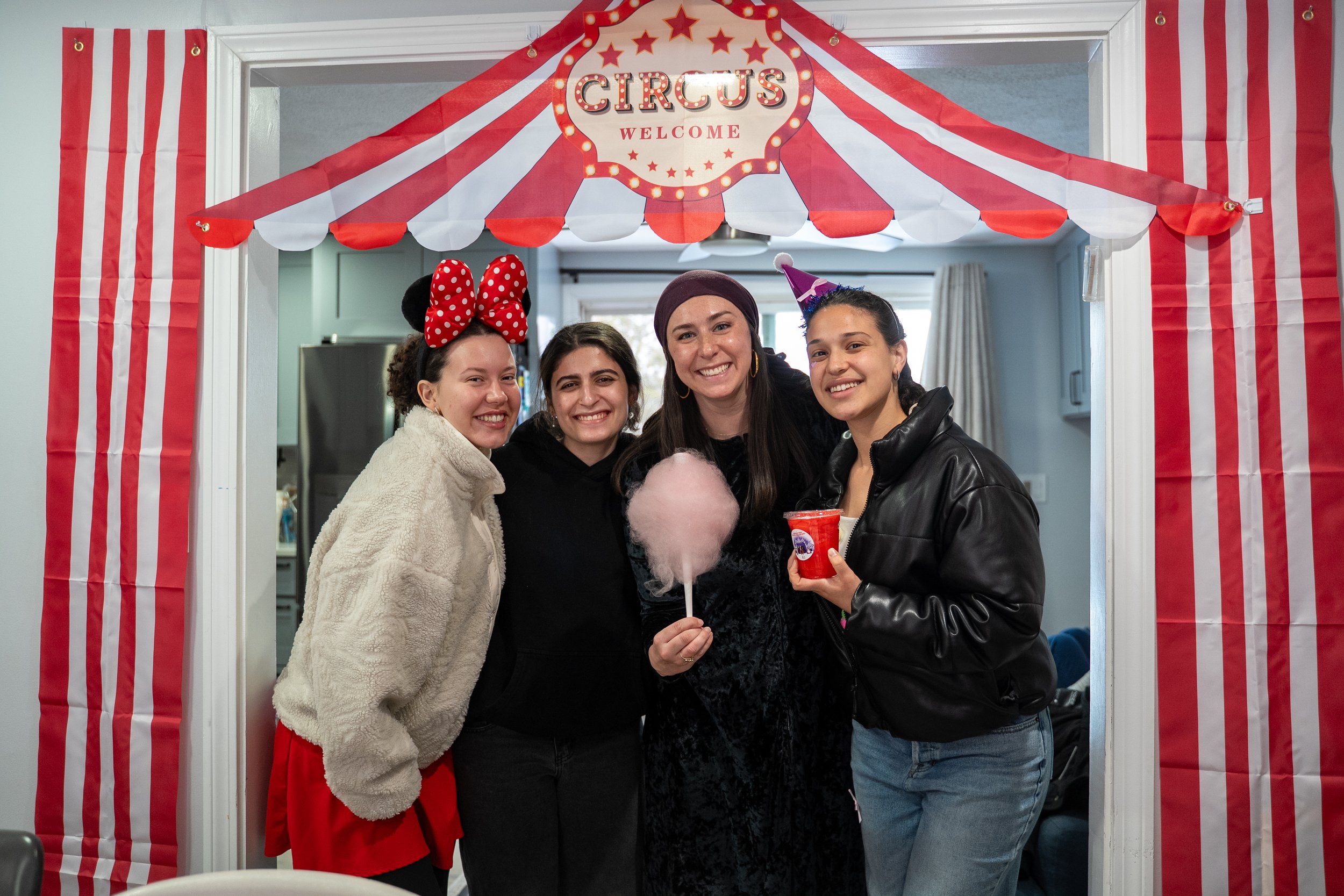 Students posing with Jenny on Purim at the JLIC house