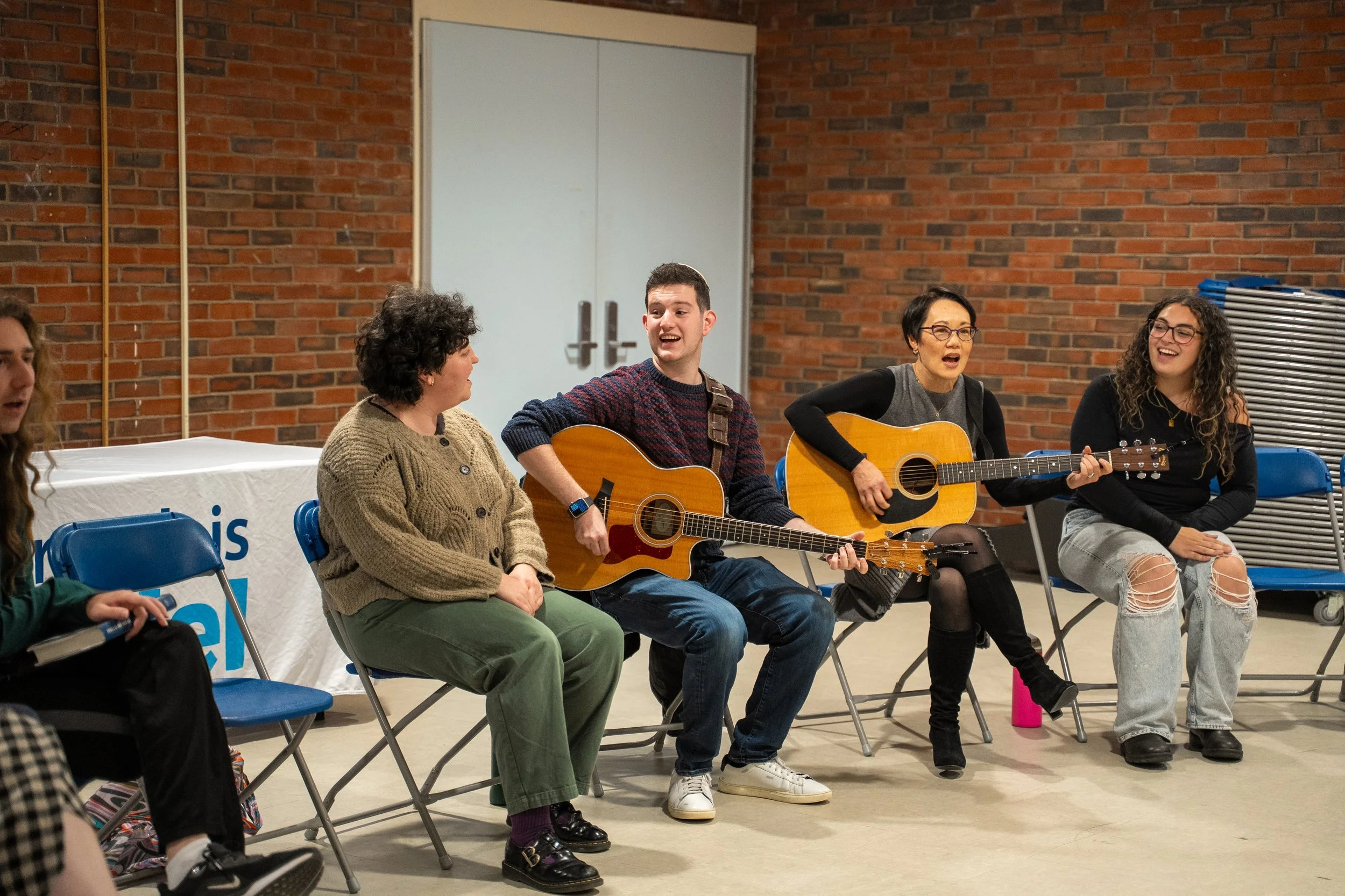 Students playing guitar and singing with Rabbi Angela Buchdahl