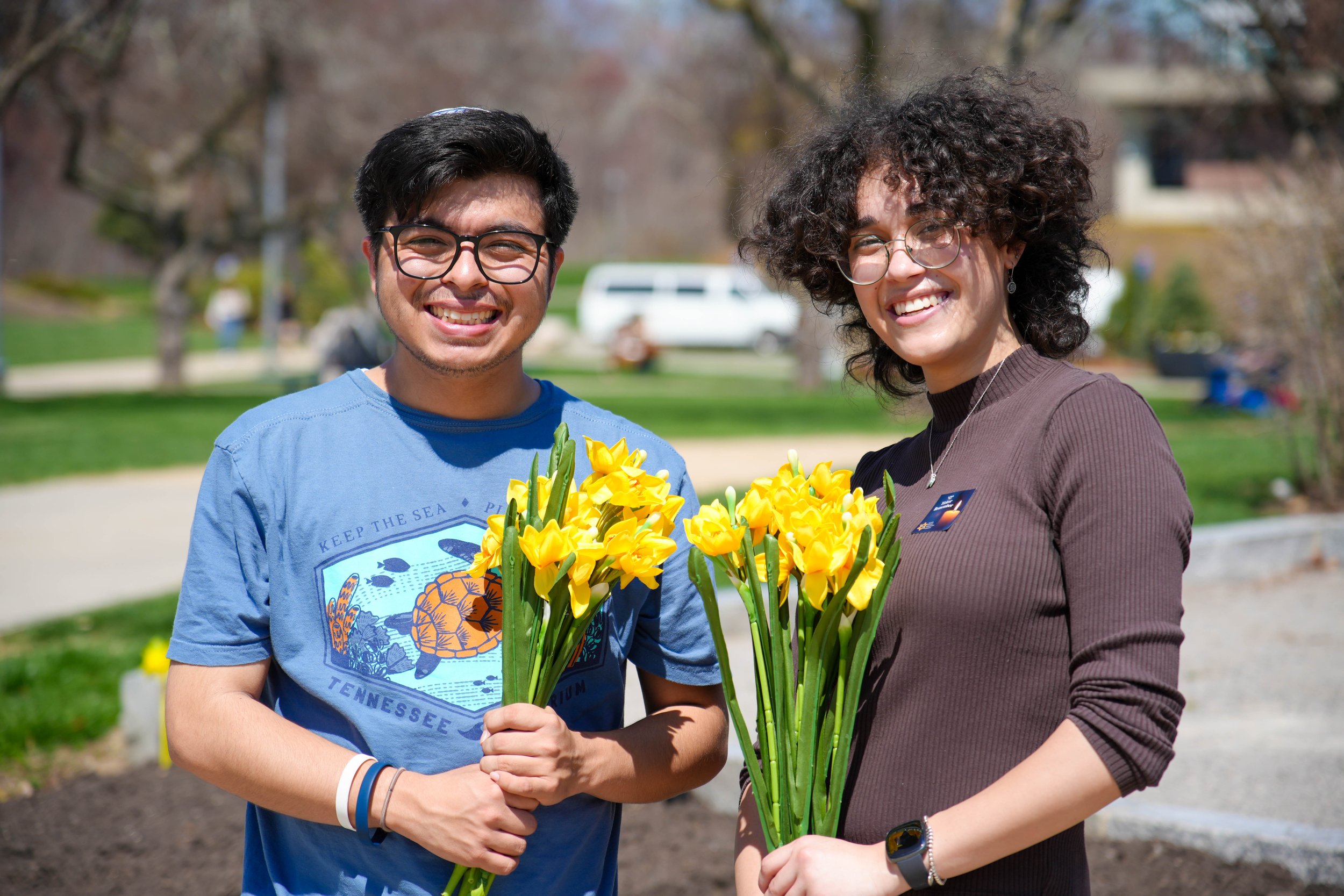 Students holding yellow daffodils at a Yom Hashoah memorial