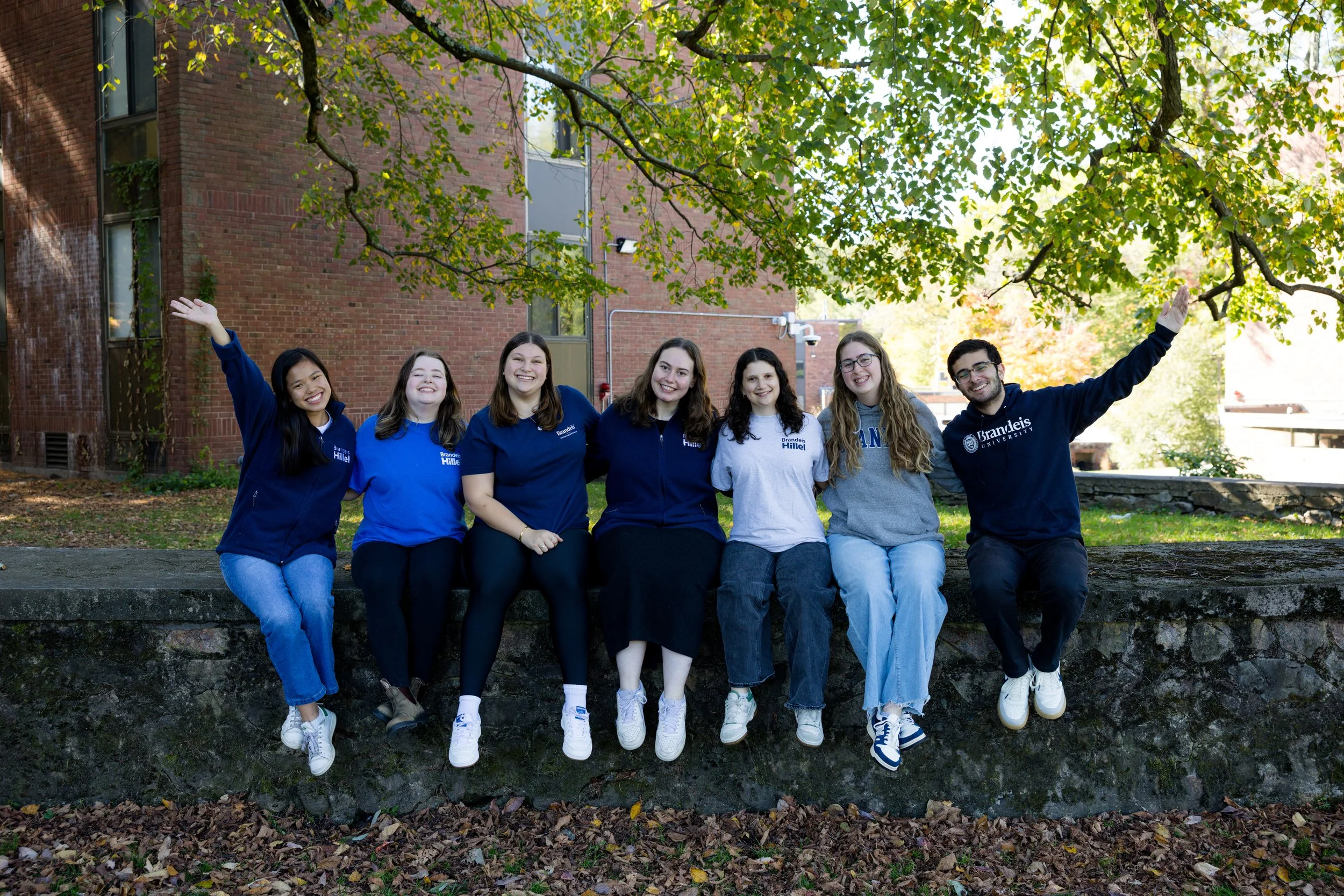 Students posing and smiling, wearing Brandeis Hillel shirts