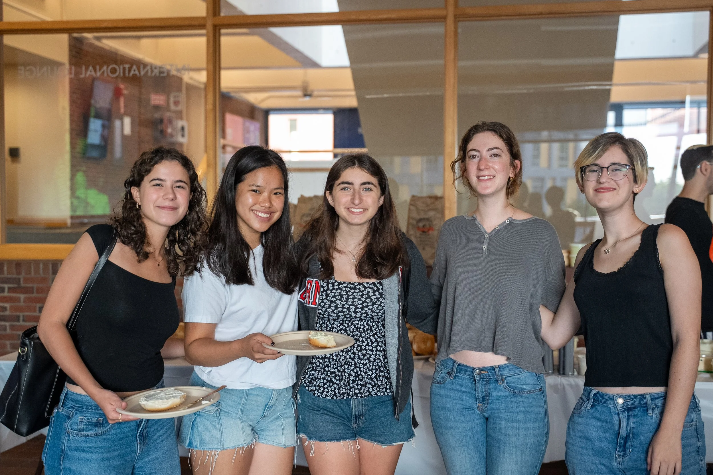Students posing with bagels from the Bagel Brunch Fall 2025