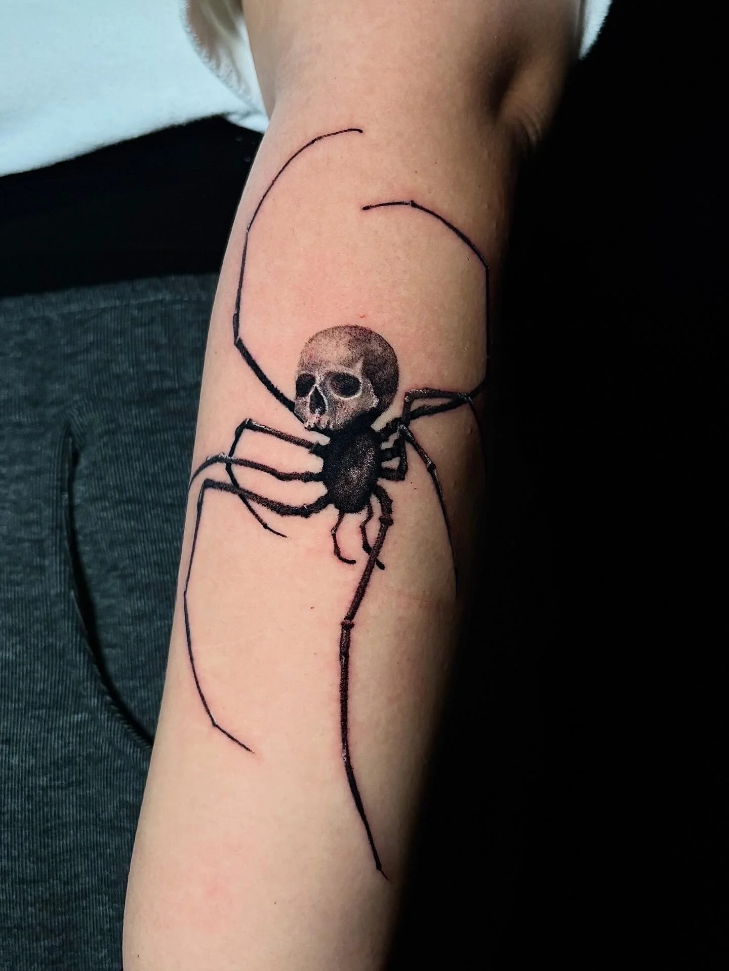 Tattoo of a spider with a skull face on a person's arm. Surrealism Tattoo Done by Pablo at Ink Terminal Ottawa Gatineau