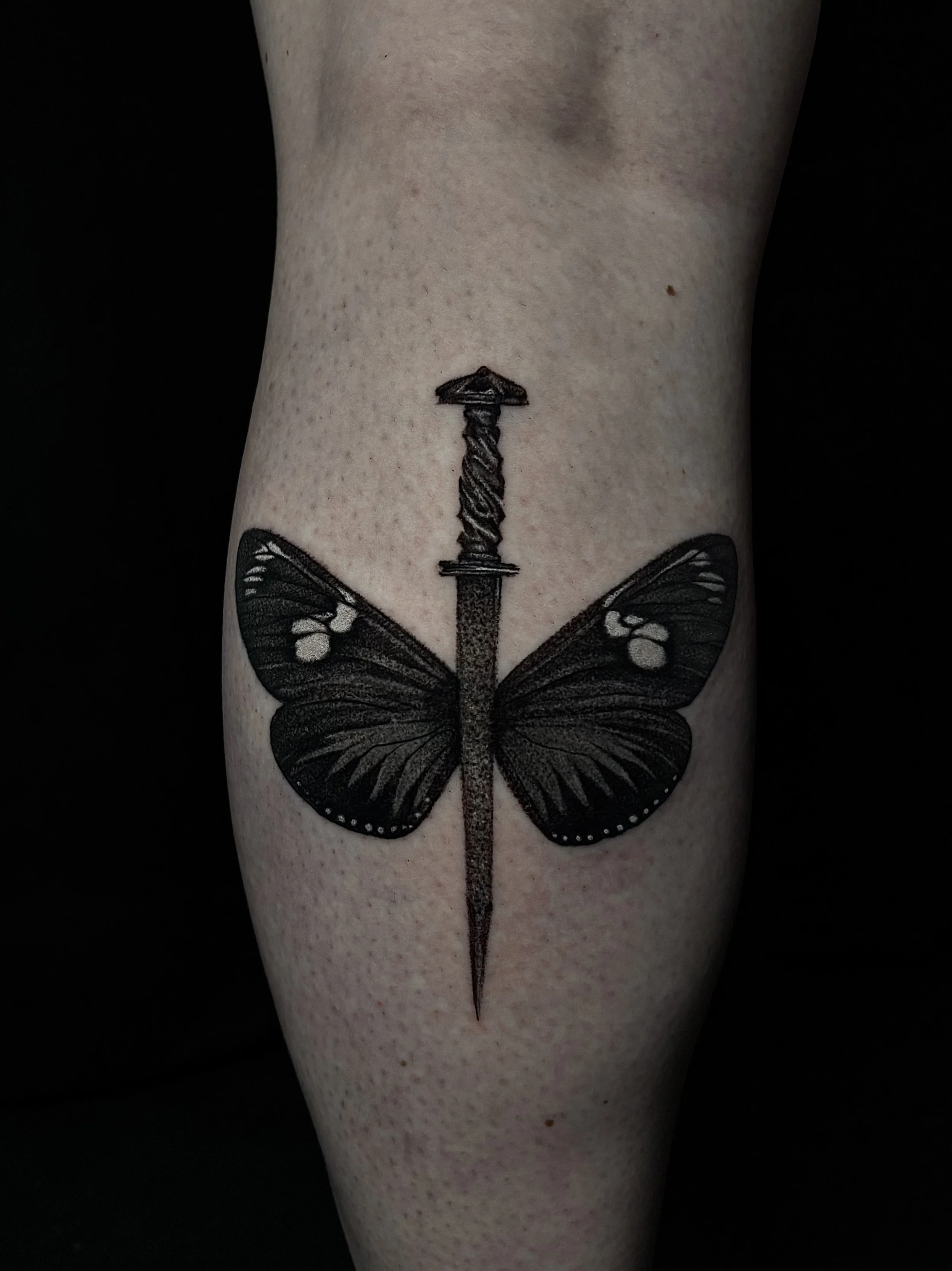 Tattoo of a black butterfly with a sword in the middle, Surrealism Tattoo Done by Pablo at Ink Terminal Ottawa Gatineau