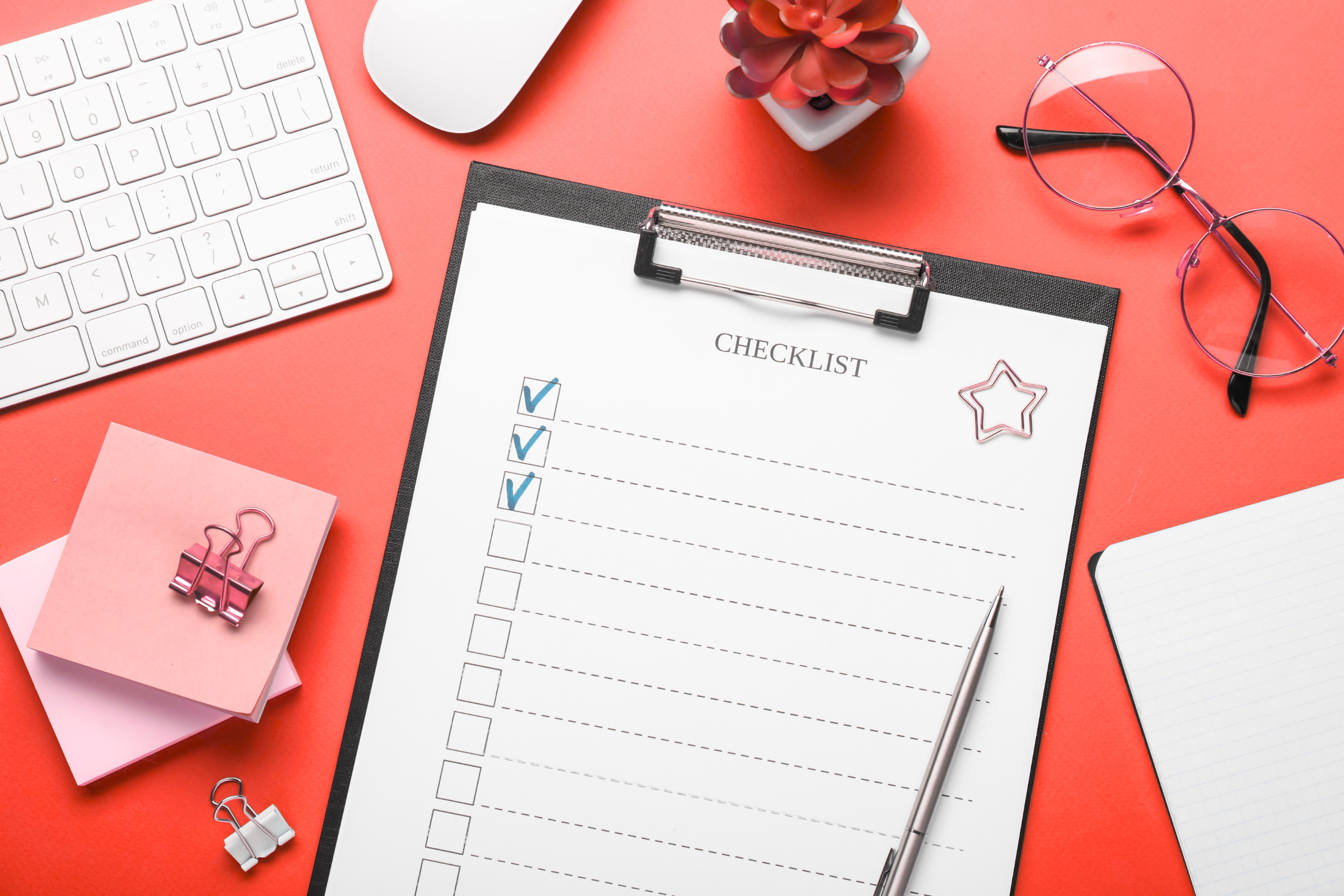 A clipboard on a desk with a paper checklist on it. Three items are checked off.