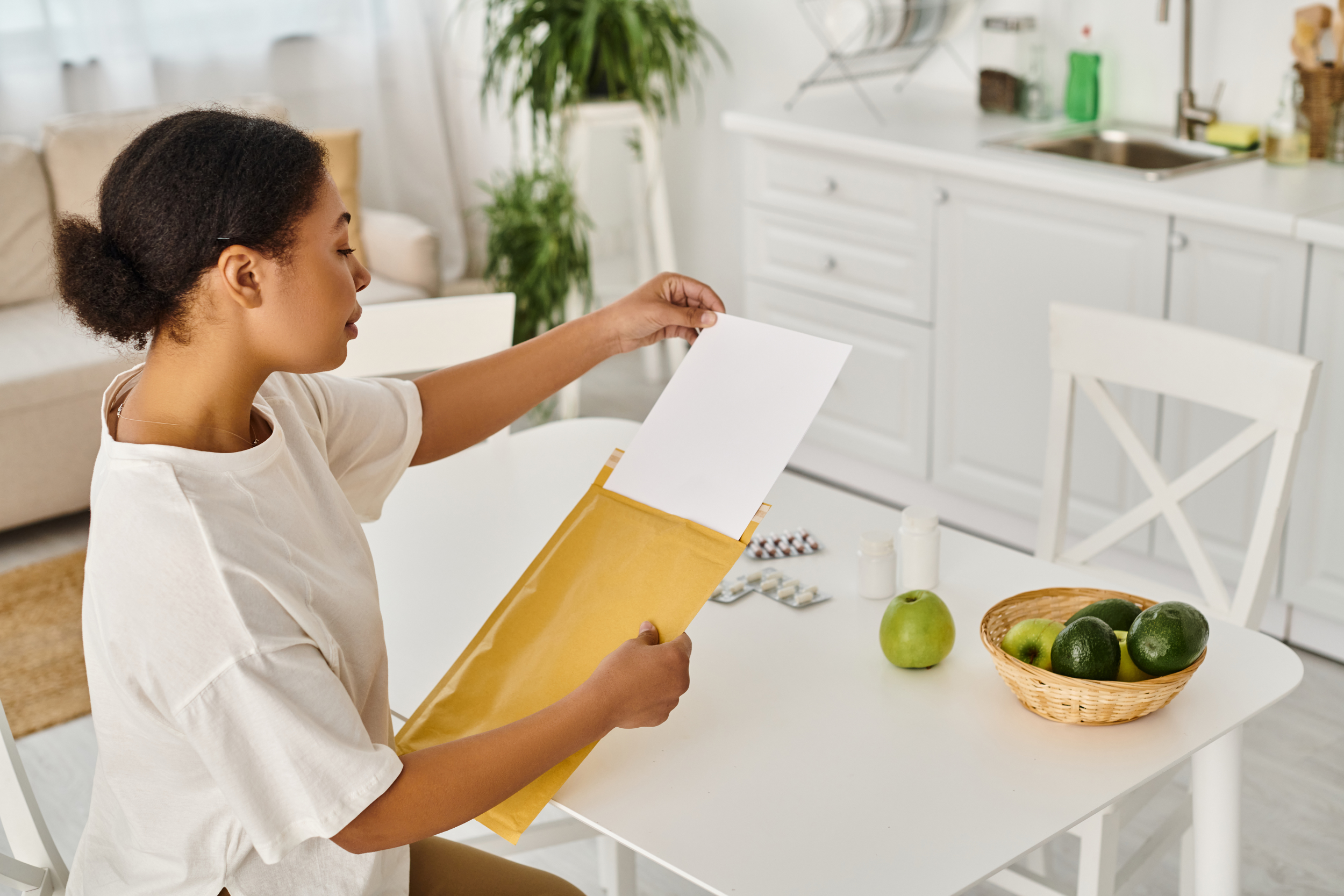 A young woman puts important medical documents into a manila envelope.