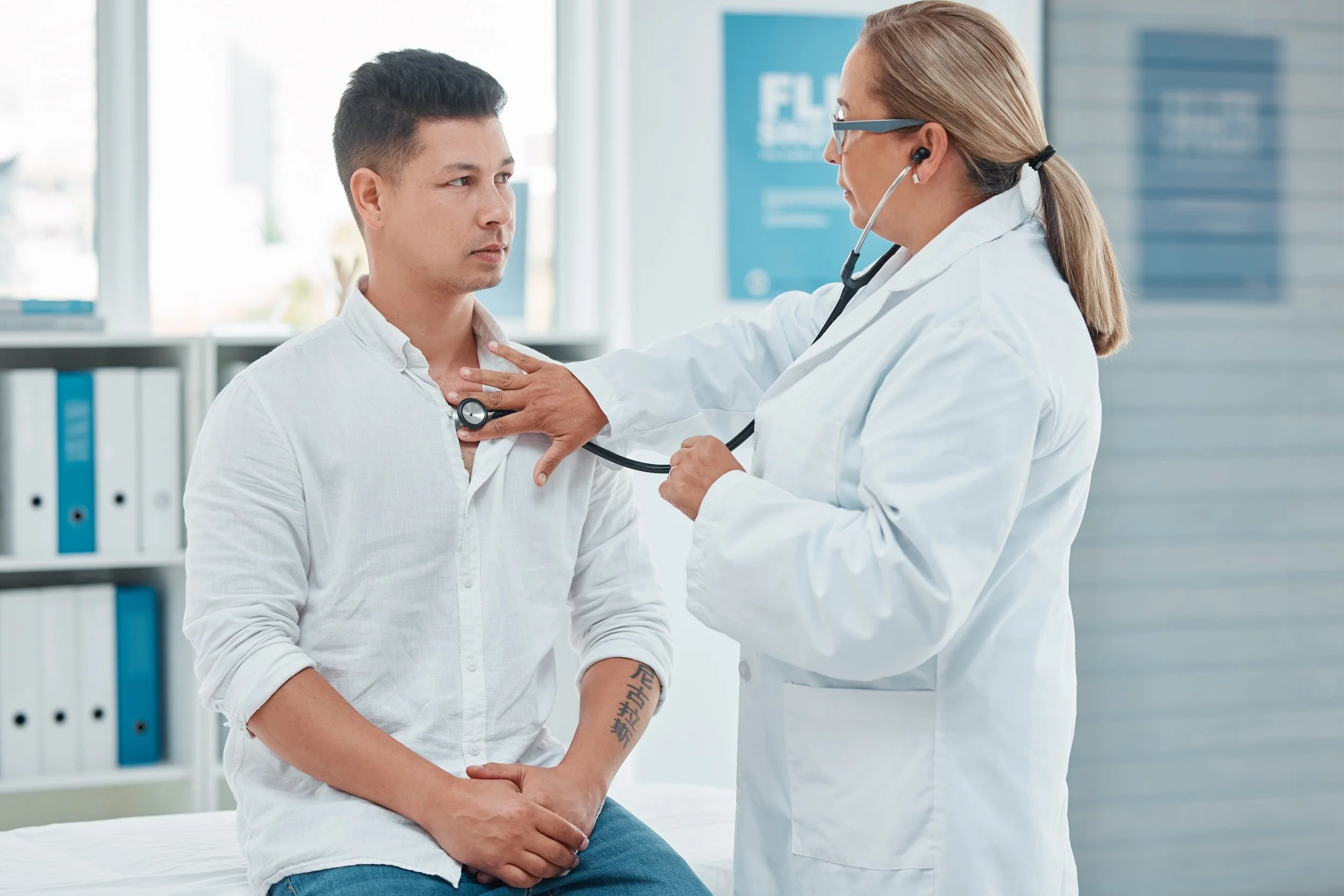 Female doctor giving a physical exam to a male patient