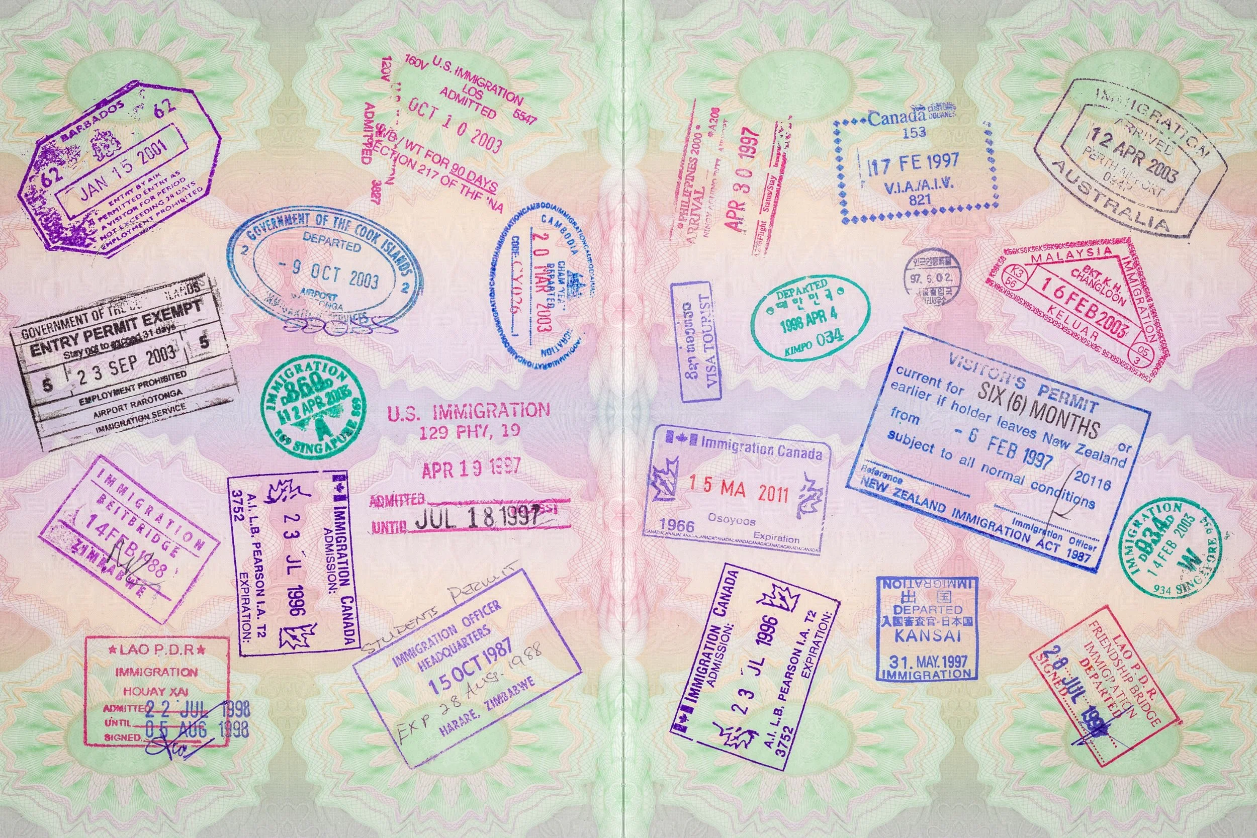 Two pages of a passport filled with immigration stamps from various countries.