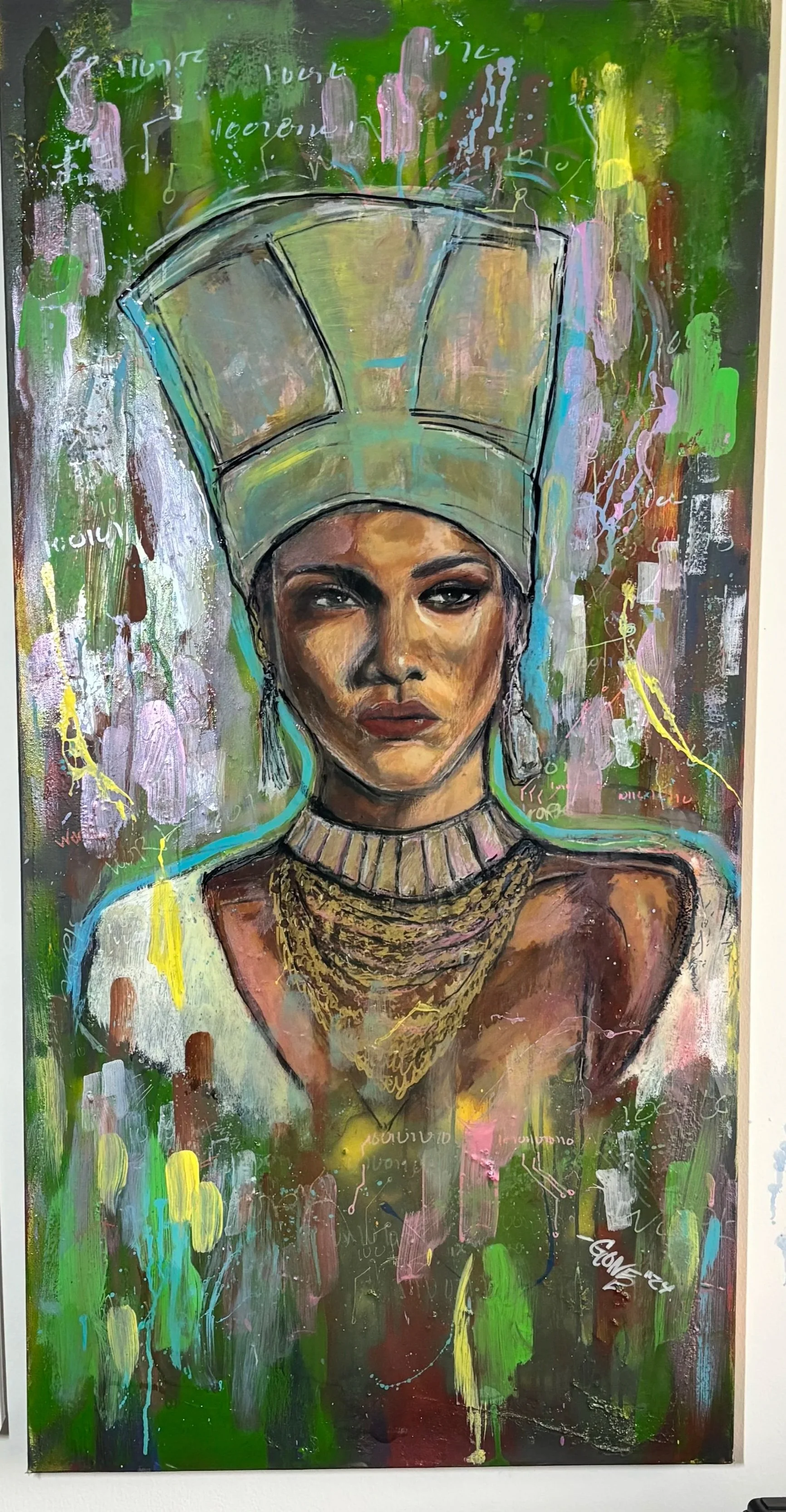 A colorful mural featuring a woman with Arabic or Middle Eastern jewelry and headscarf, painted against abstract background with vibrant green, pink, yellow, purple, and black colors.