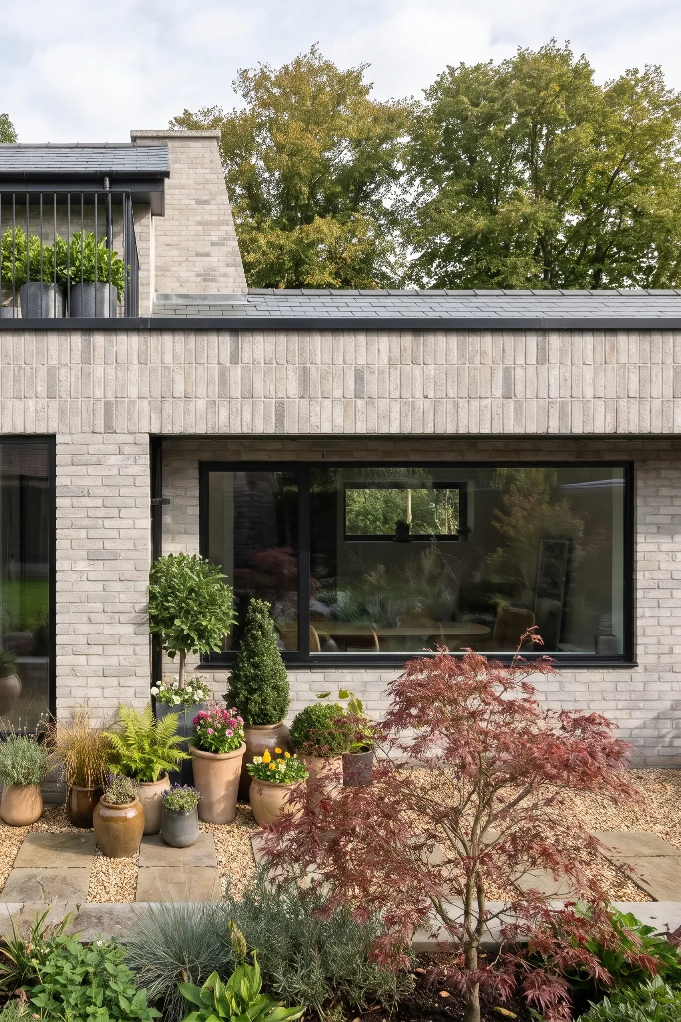 Slender black balustrades and planted pots define the balcony