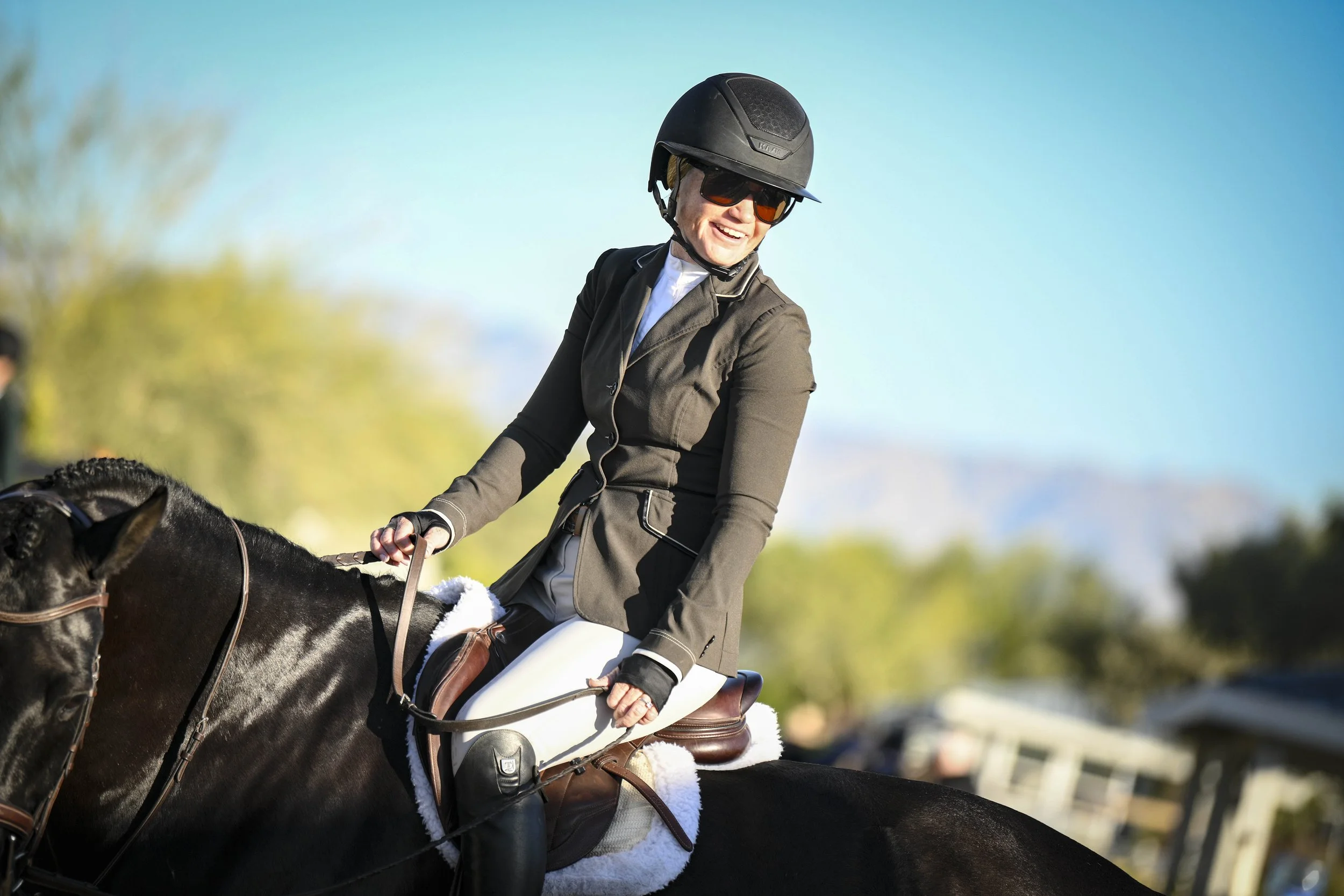 Outdoor event tent with seating and potted plants, labeled 'AG EQUESTRIAN', set on a gravel surface with a small green artificial grass border.