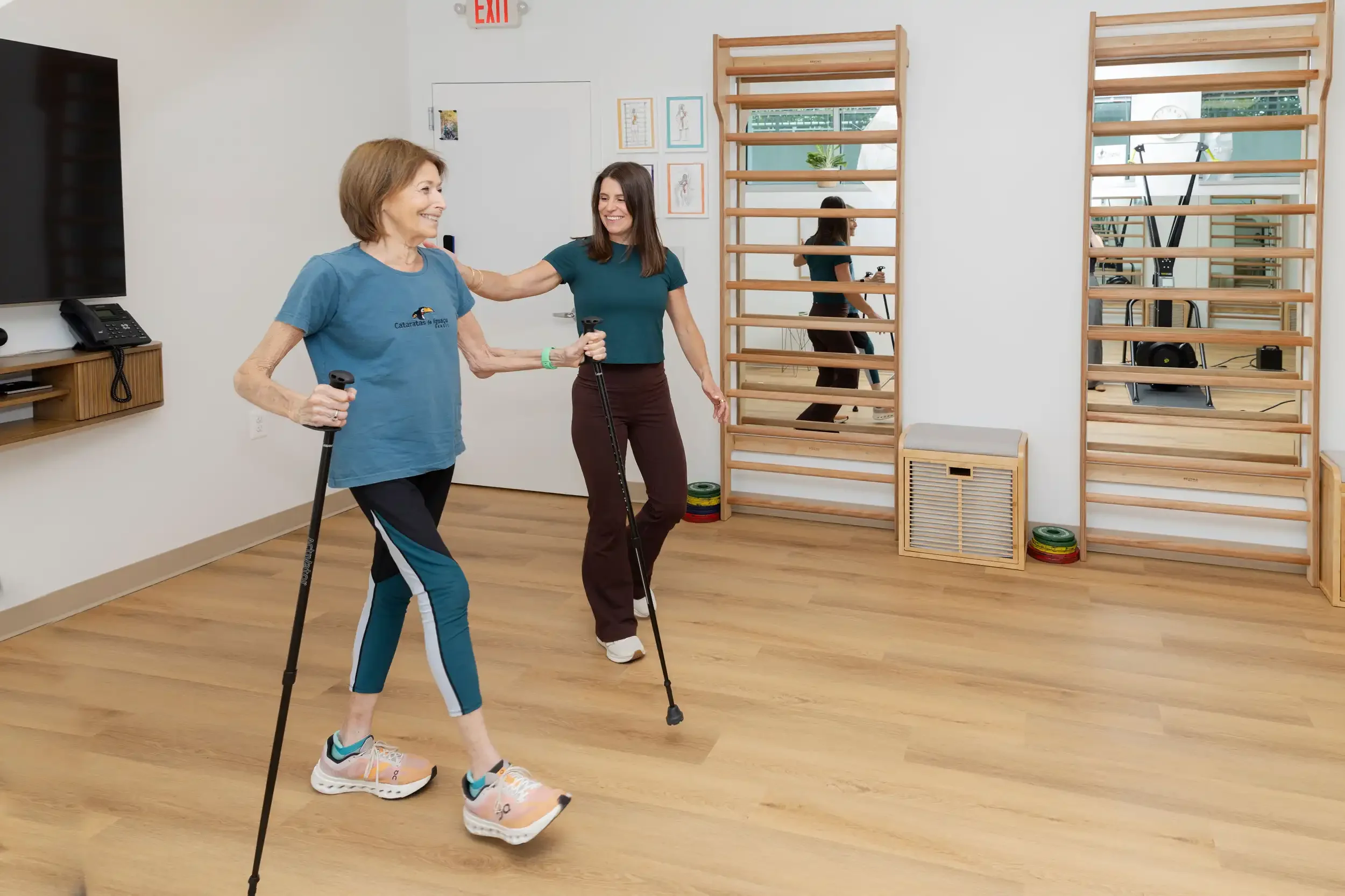 physical therapist guiding a senior patient rehabilitating with walking sticks