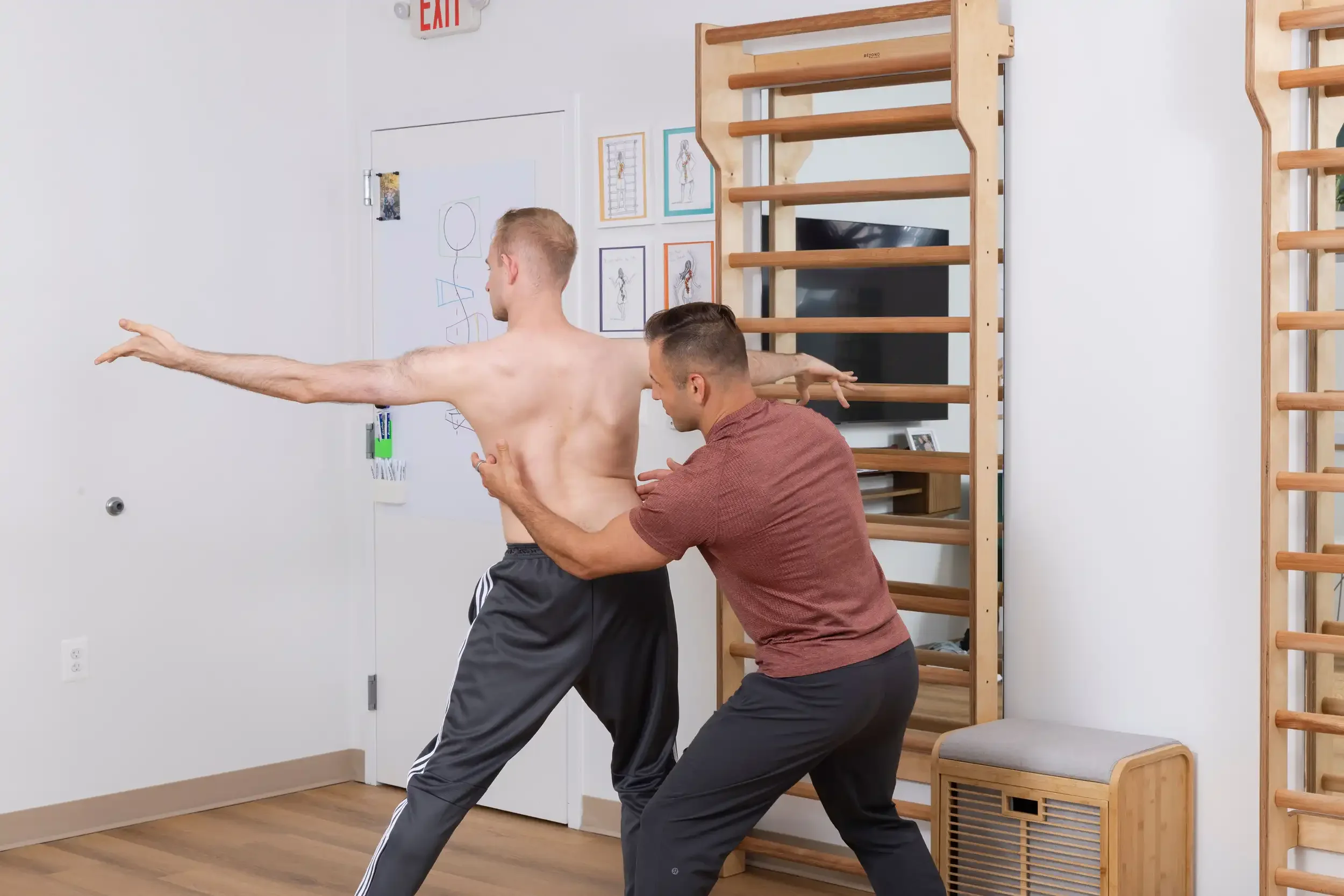 physical therapist guiding an adult patient in a standing Schroth exercise
