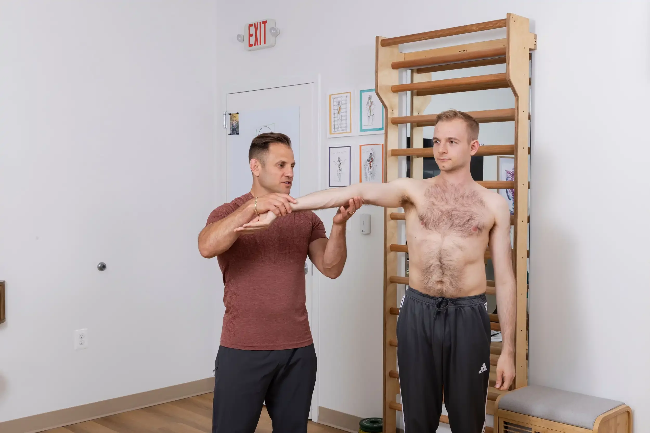 physical therapist showing hypermobility of the arms on an adult patient