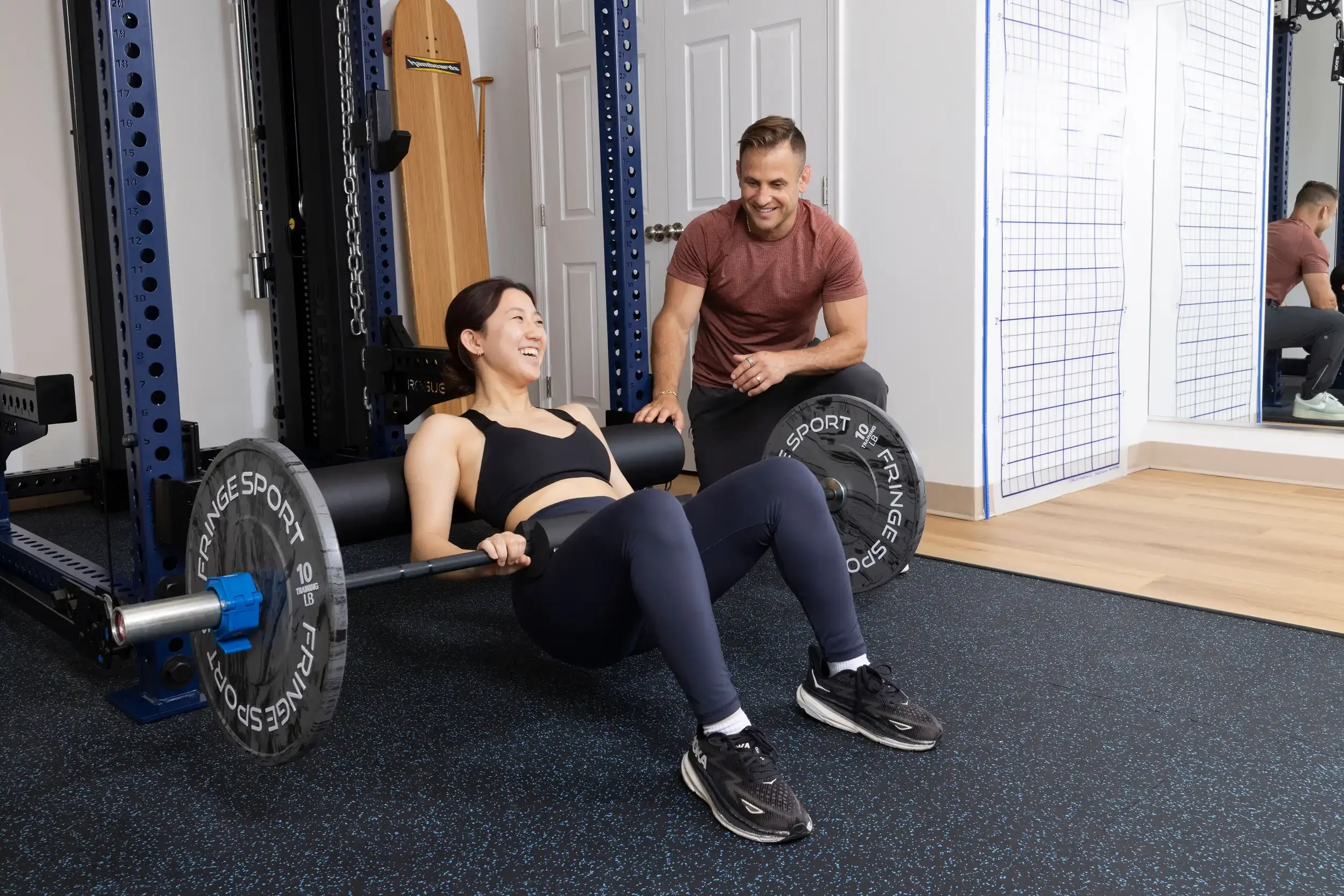 physical therapist guide an adult patient lying on a workout bench with a barbell