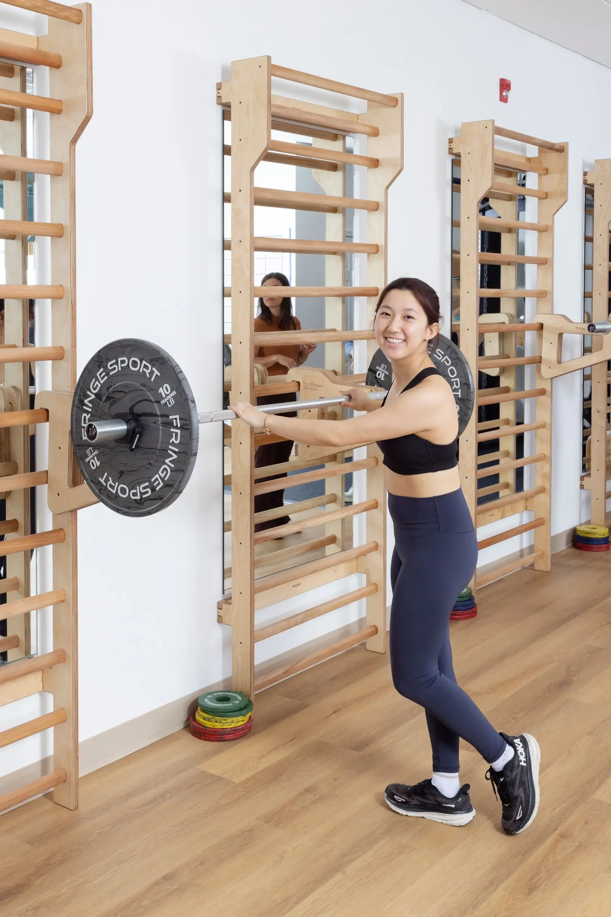 woman lifting a barbell with weights in the fairfax clinic