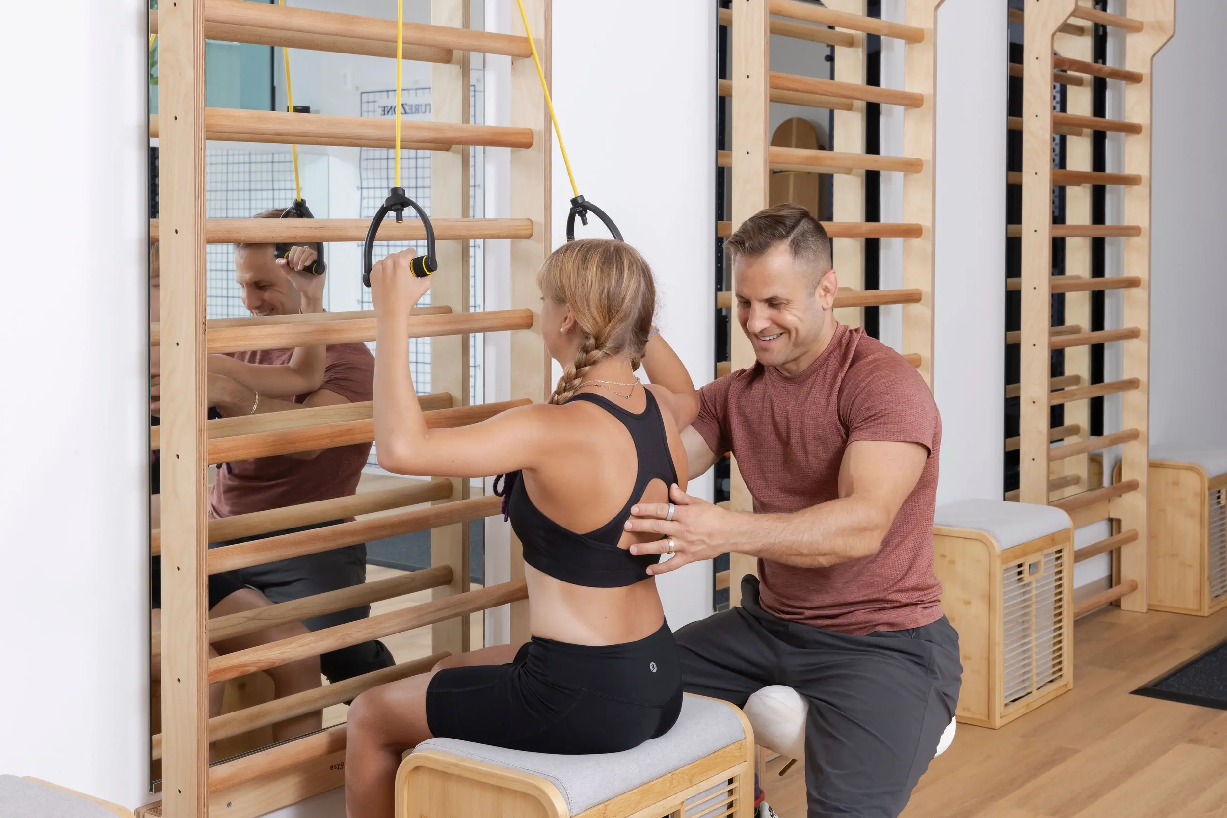 physical therapist guiding a teenage patient in a seated Schroth exercise