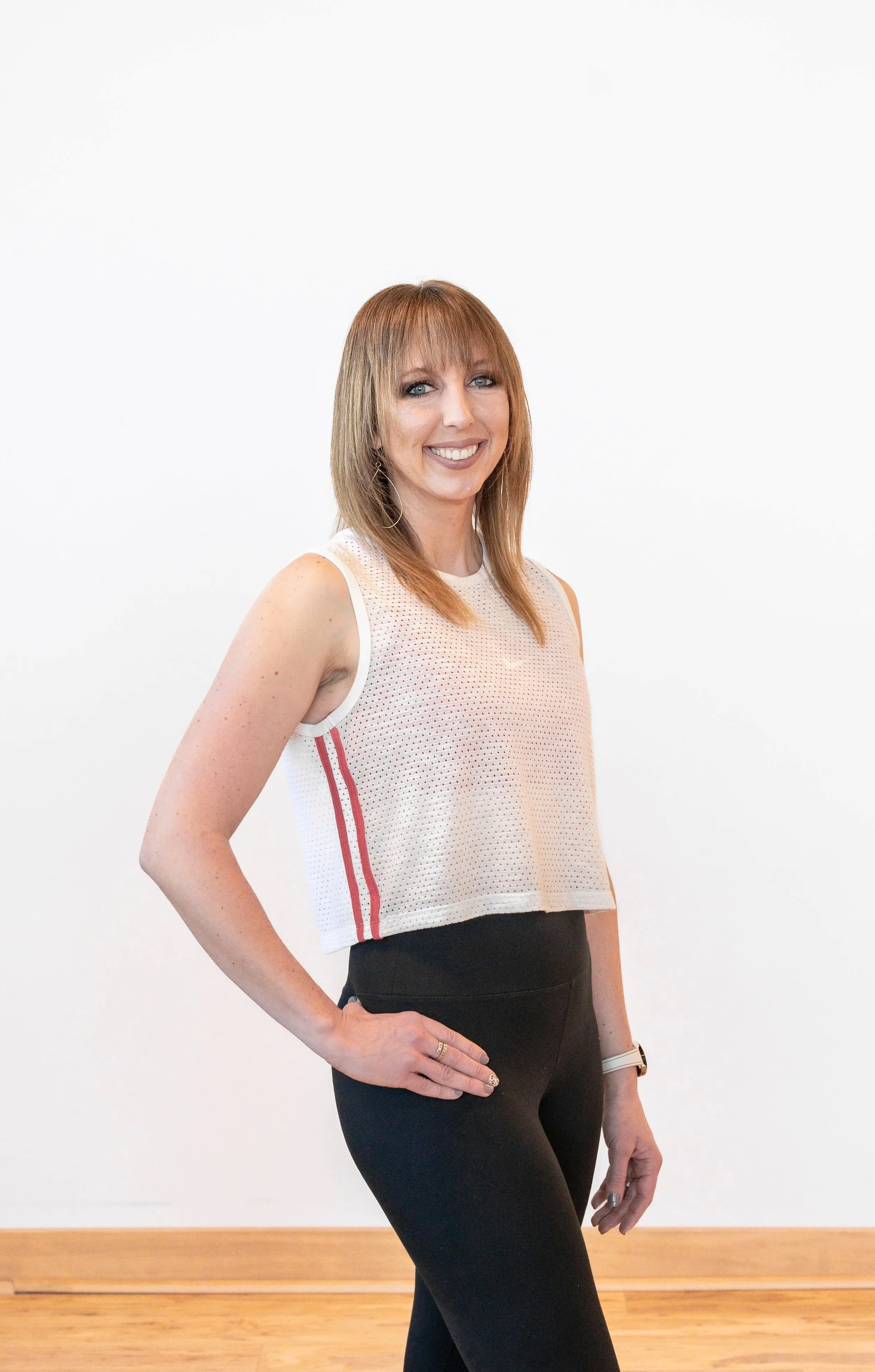 Brunette woman standing against a plain colored background