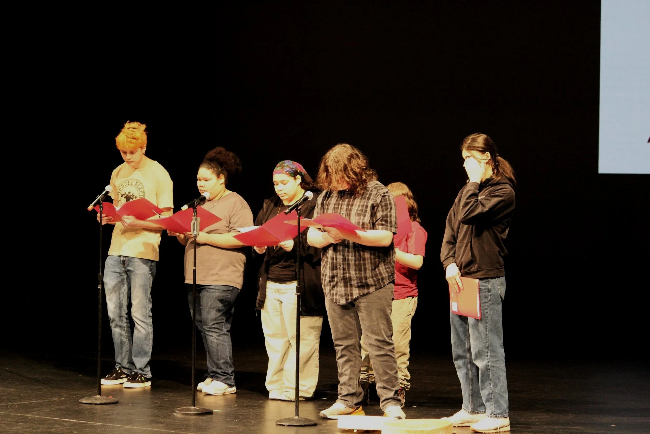 A group from Red Eagle Soaring Theatre performs the land acknowledgement on stage.