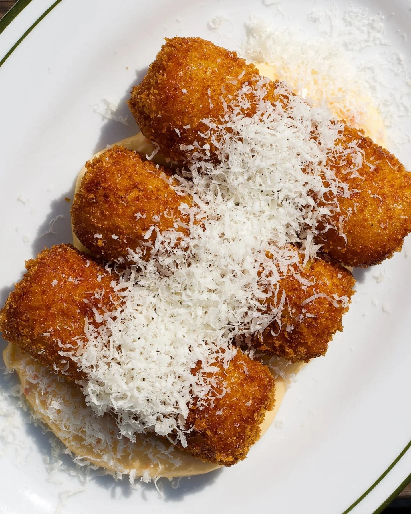 Arancini topped with grated parmesan