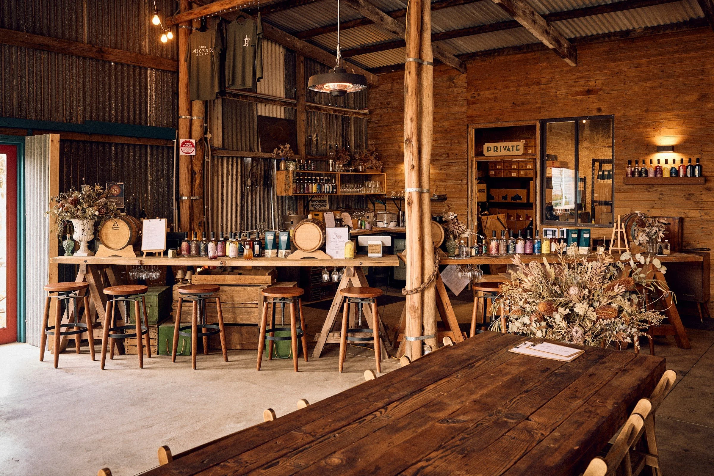 Inside The Spirit Door, with timber bar stools, barrels and shelves of Lost Phoenix Spirits